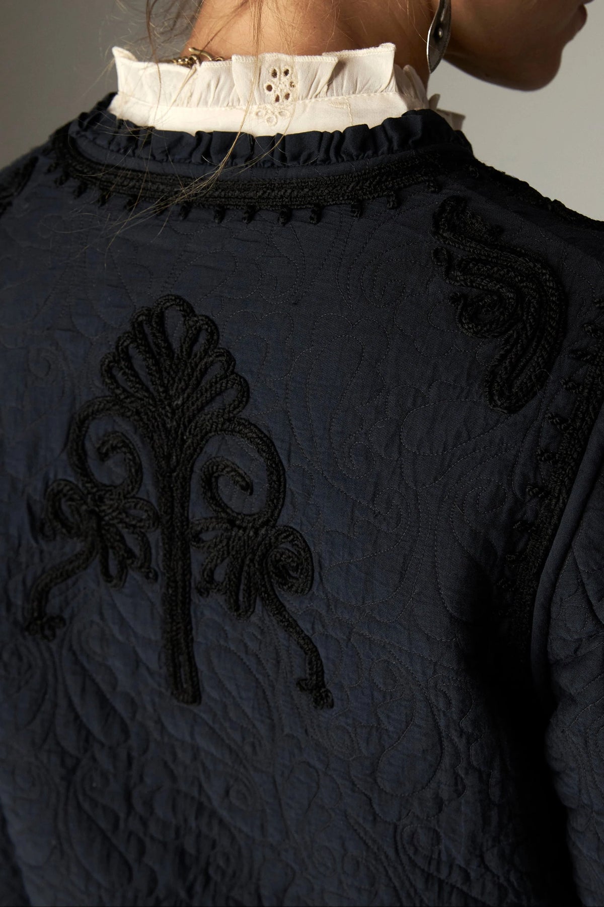 Shop the Maison Hotel Paco Jacket in Ceniza at Dotique. A cropped collarless jacket with embroidered trims, an open front and patch pockets.