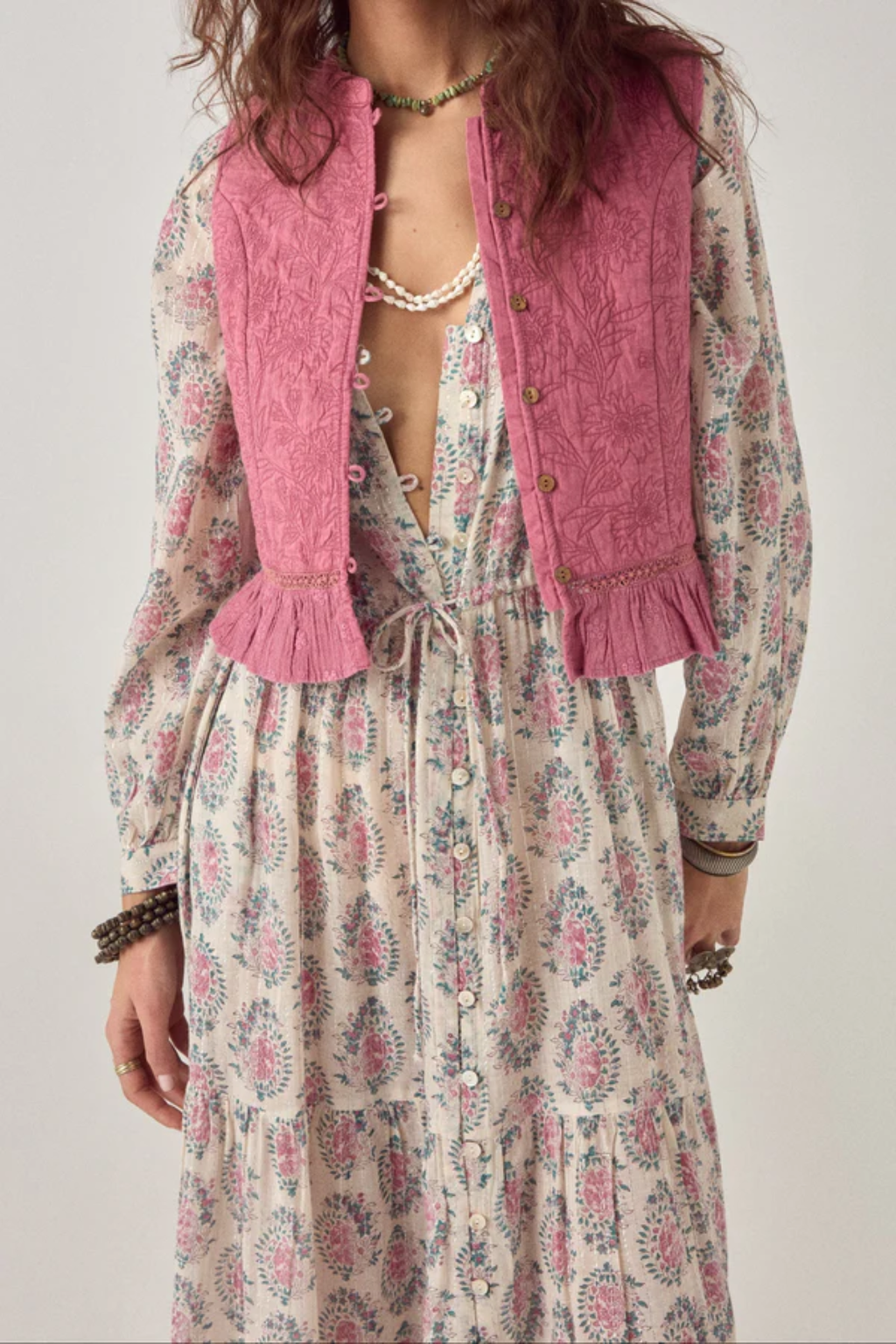 Woman wearing Maison Hotel Mia Vest Peonia Punk Pink over floral dress by Maison Hotel, shop Maison Hotel at Dotique