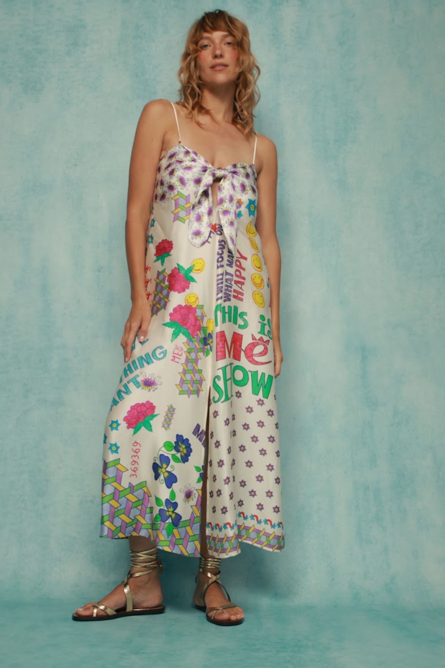 Woman wearing Me369 Eli Markers Stripeless Dress by Me369 standing against blue wall Shop Me369 at Dotique