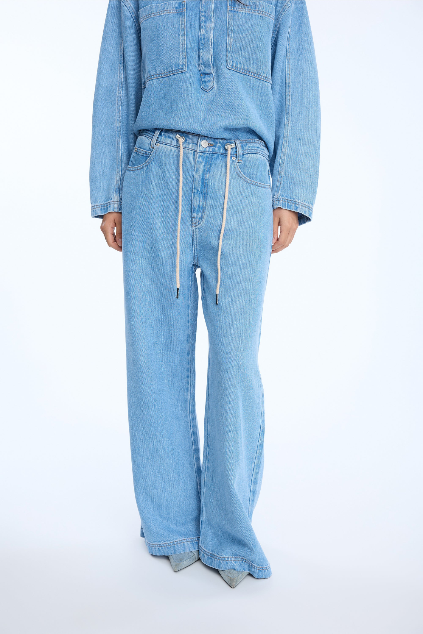 Shop the MUNTHE Obey Trousers in Light Blue at Dotique. Crafted from 100% TENCEL™ with a flattering wide-leg fit, tie waist and soft denim-look finish.