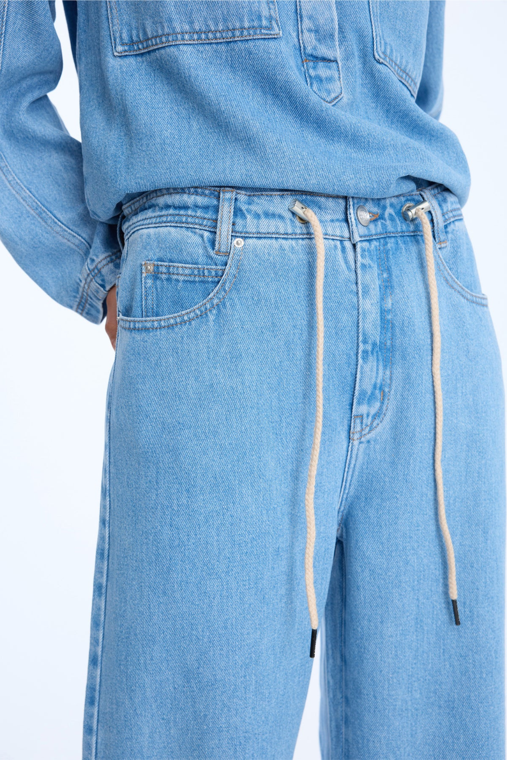 Shop the MUNTHE Obey Trousers in Light Blue at Dotique. Crafted from 100% TENCEL™ with a flattering wide-leg fit, tie waist and soft denim-look finish.