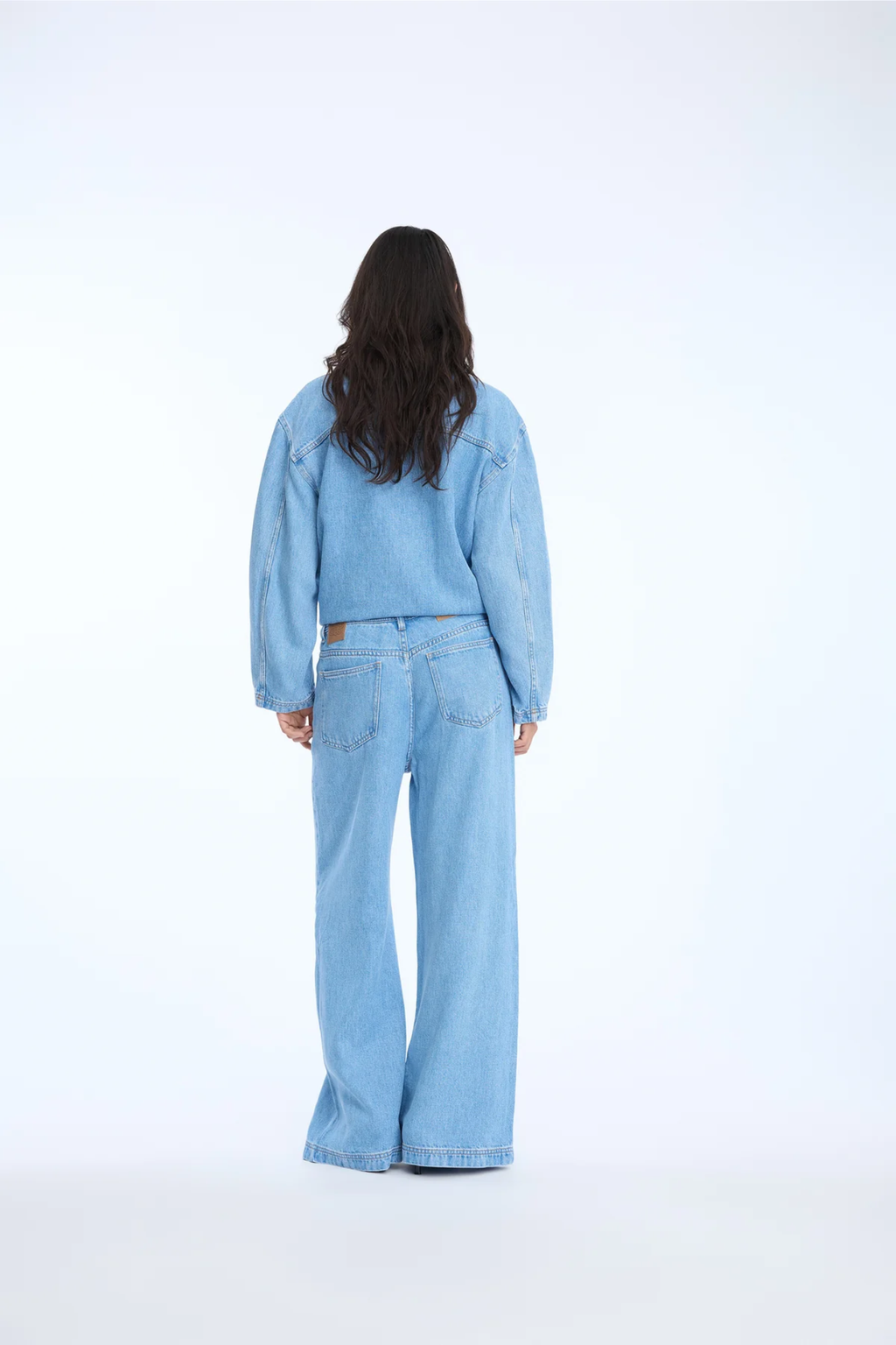 Shop the MUNTHE Obey Trousers in Light Blue at Dotique. Crafted from 100% TENCEL™ with a flattering wide-leg fit, tie waist and soft denim-look finish.