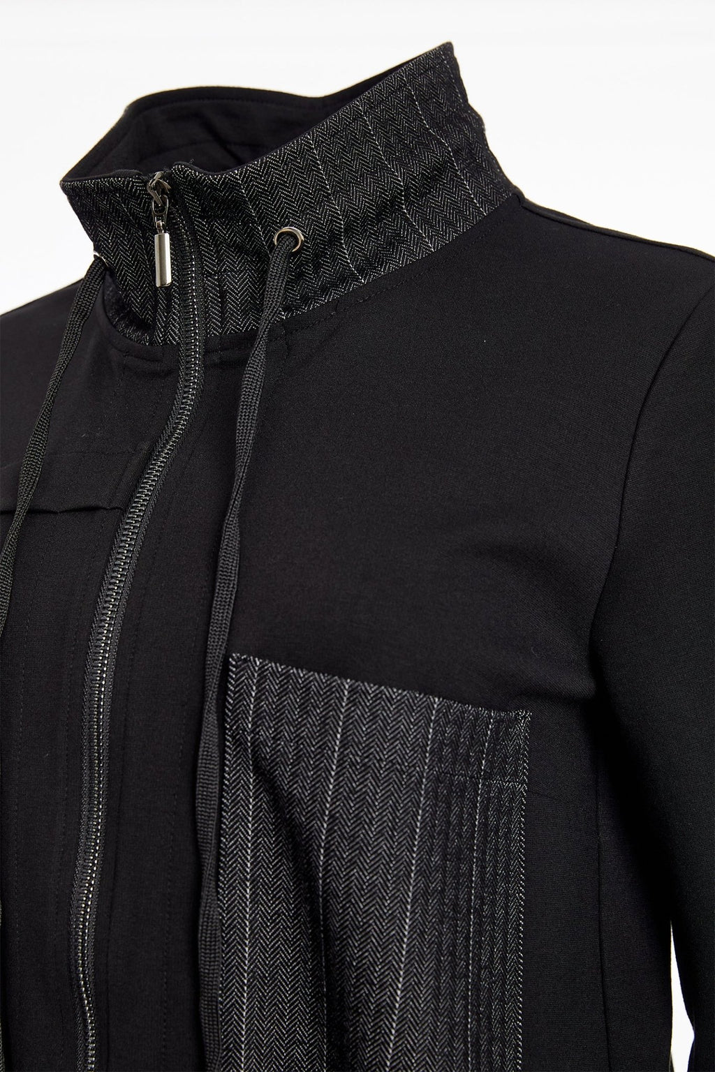 Close-up of a black jacket with a textured collar and pocket detail on a white background