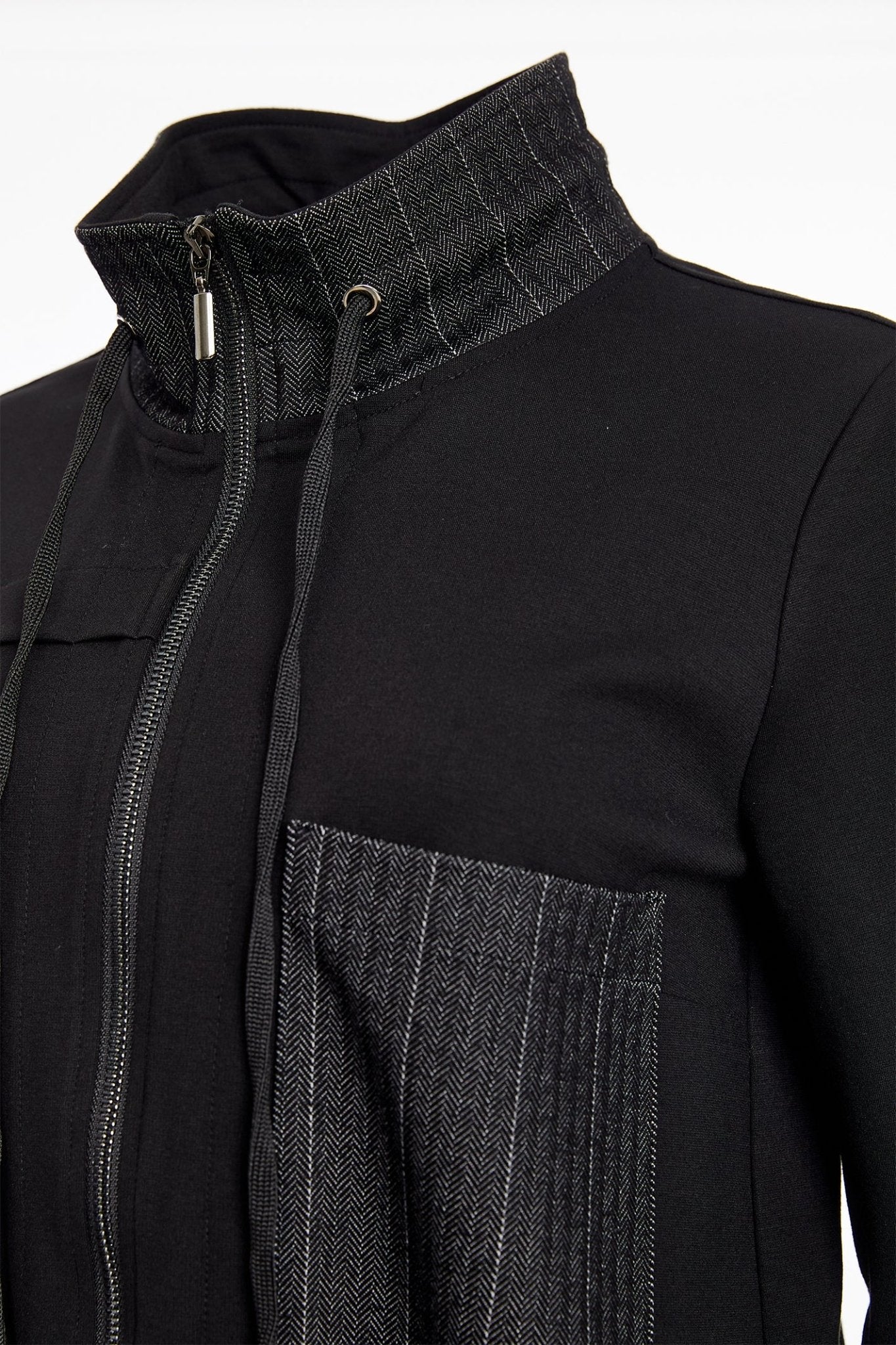 Close-up of a black jacket with a textured collar and pocket detail on a white background