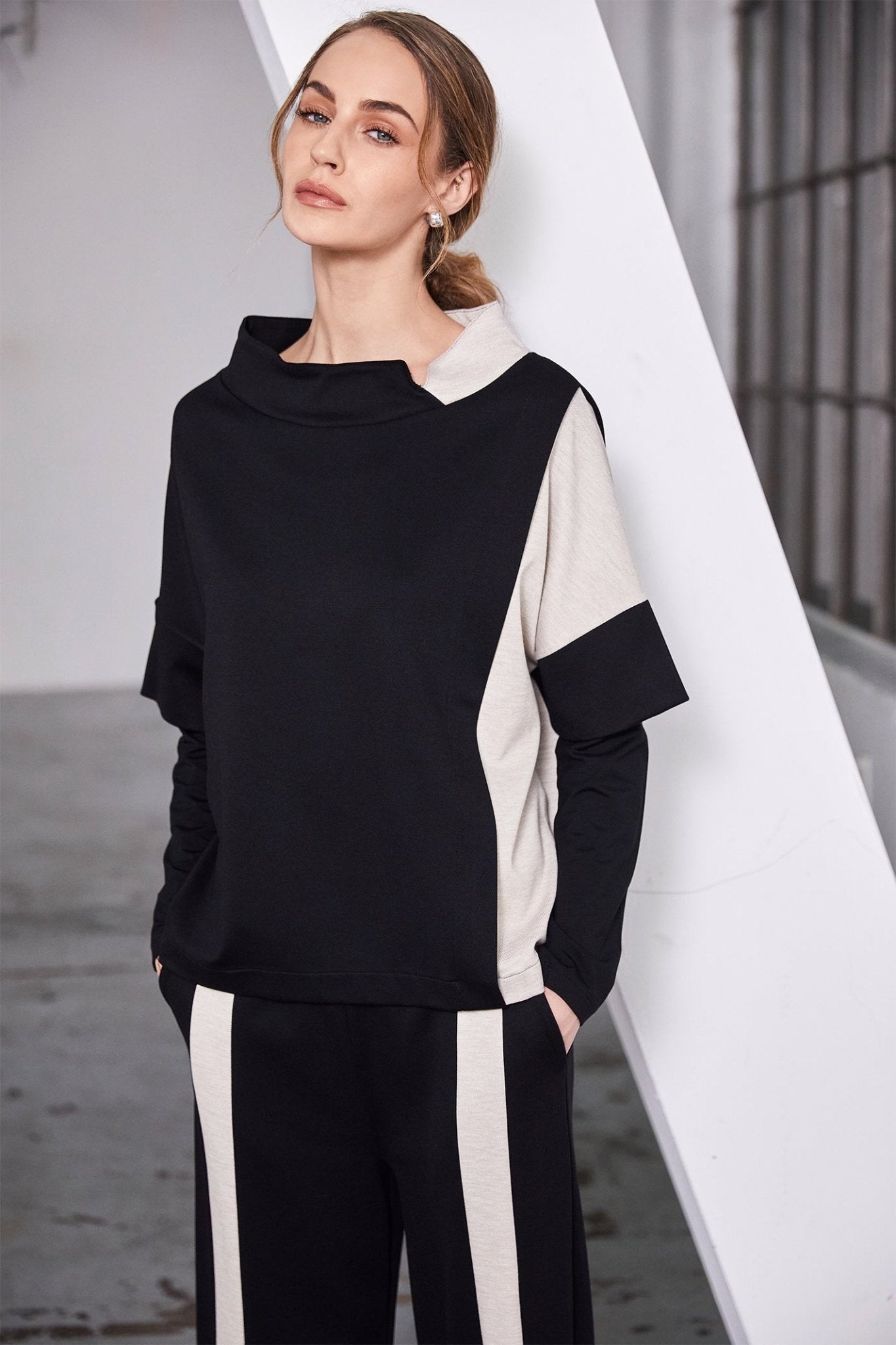 Woman wearing a black and white outfit with a geometric background