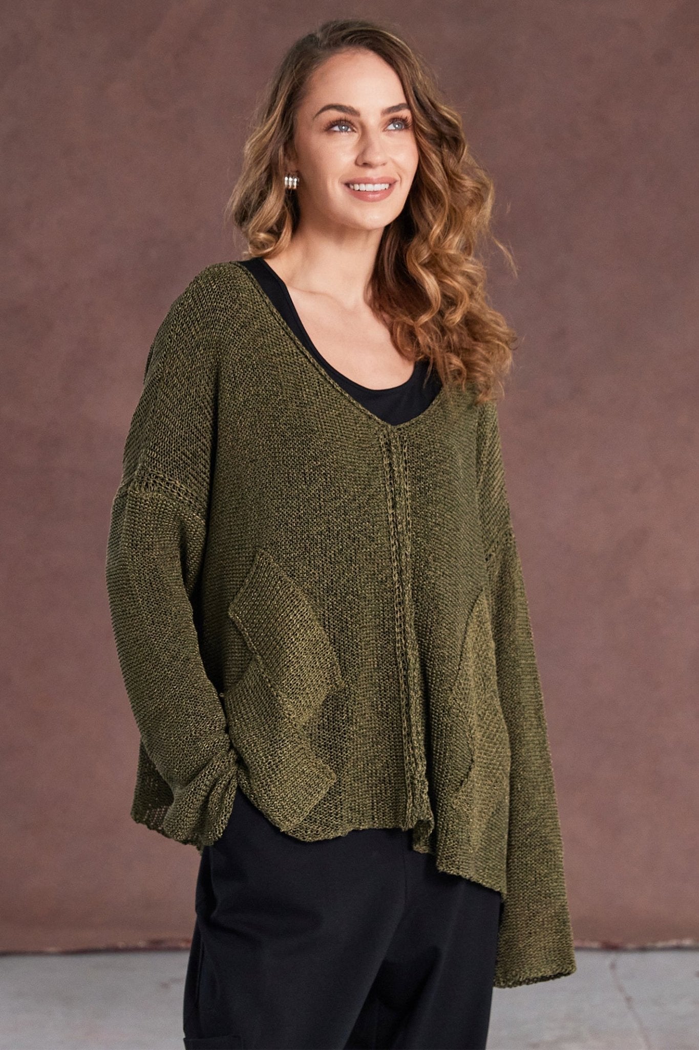 Woman wearing a green sweater against a brown background