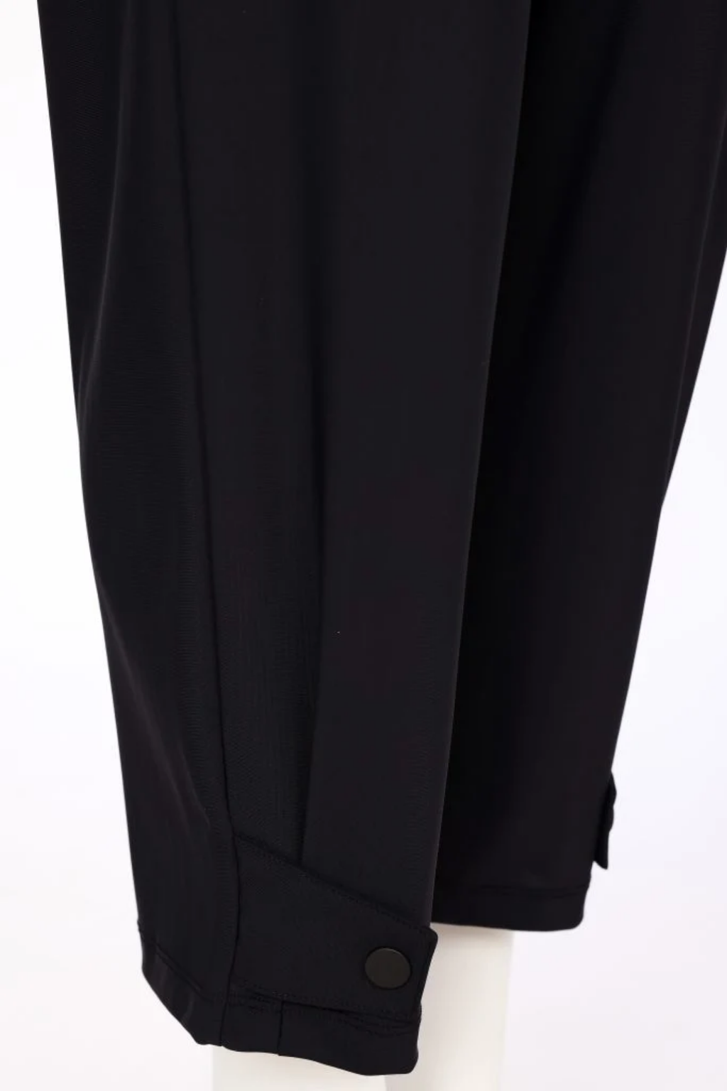 Shop NAYA Black Drawstring Tab Hem Trousers NAW26116 at Dotique. A tapered stretch trouser with an elasticated waist, pockets and button-tab hem detail.