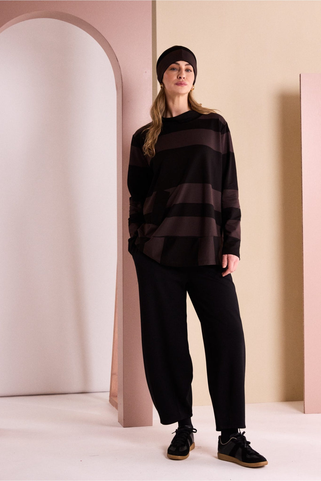 Naya NAW26144 Balloon Shaped Trouser with Darts at Hem Black styled on model. Shop Naya at Dotique