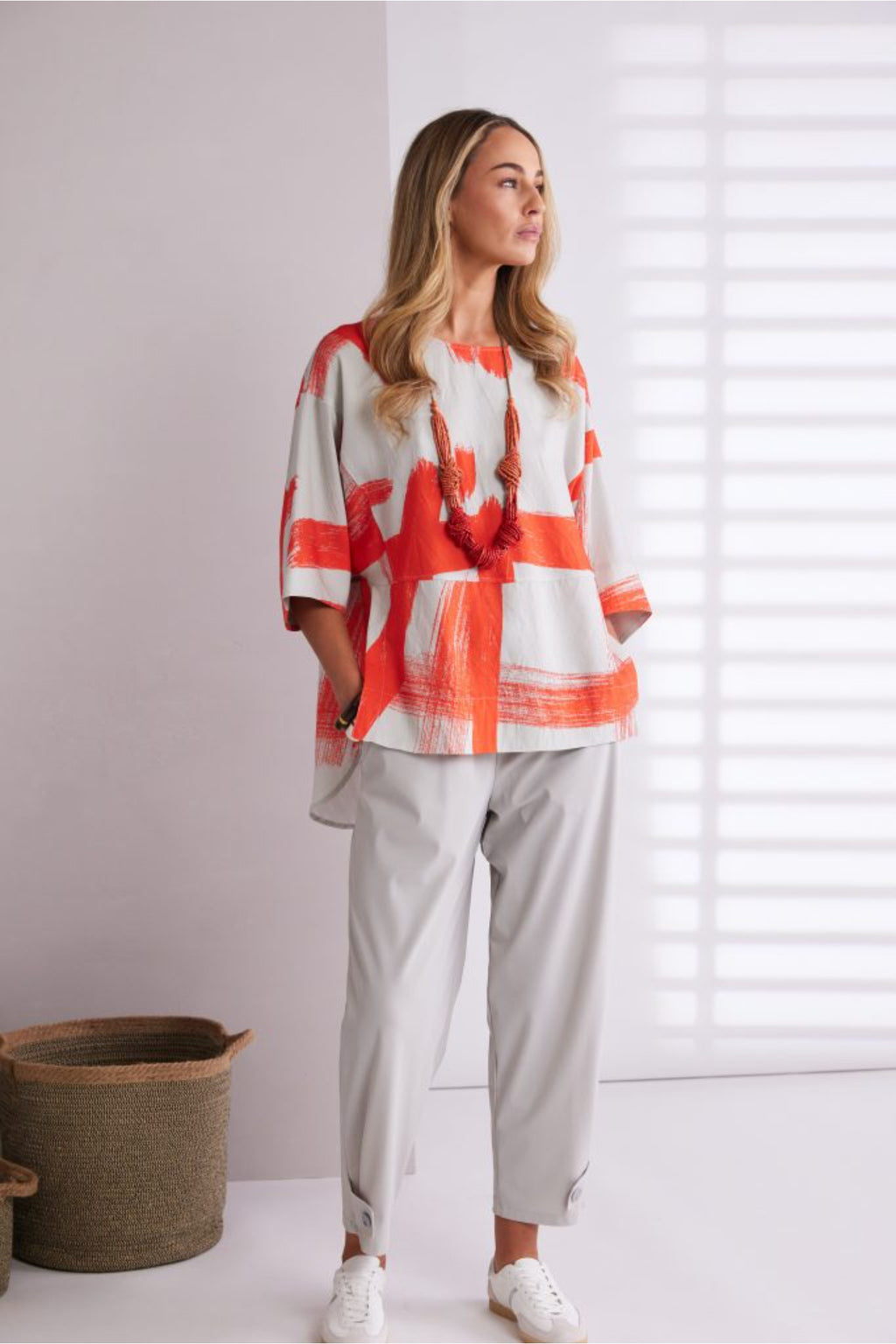 NAYA paintwork print top in coral and ivory featuring an abstract brushstroke design, round neckline, deep cuffed short sleeves and a relaxed fit with a shaped hemline. Shop at Dotique Chesterfield.