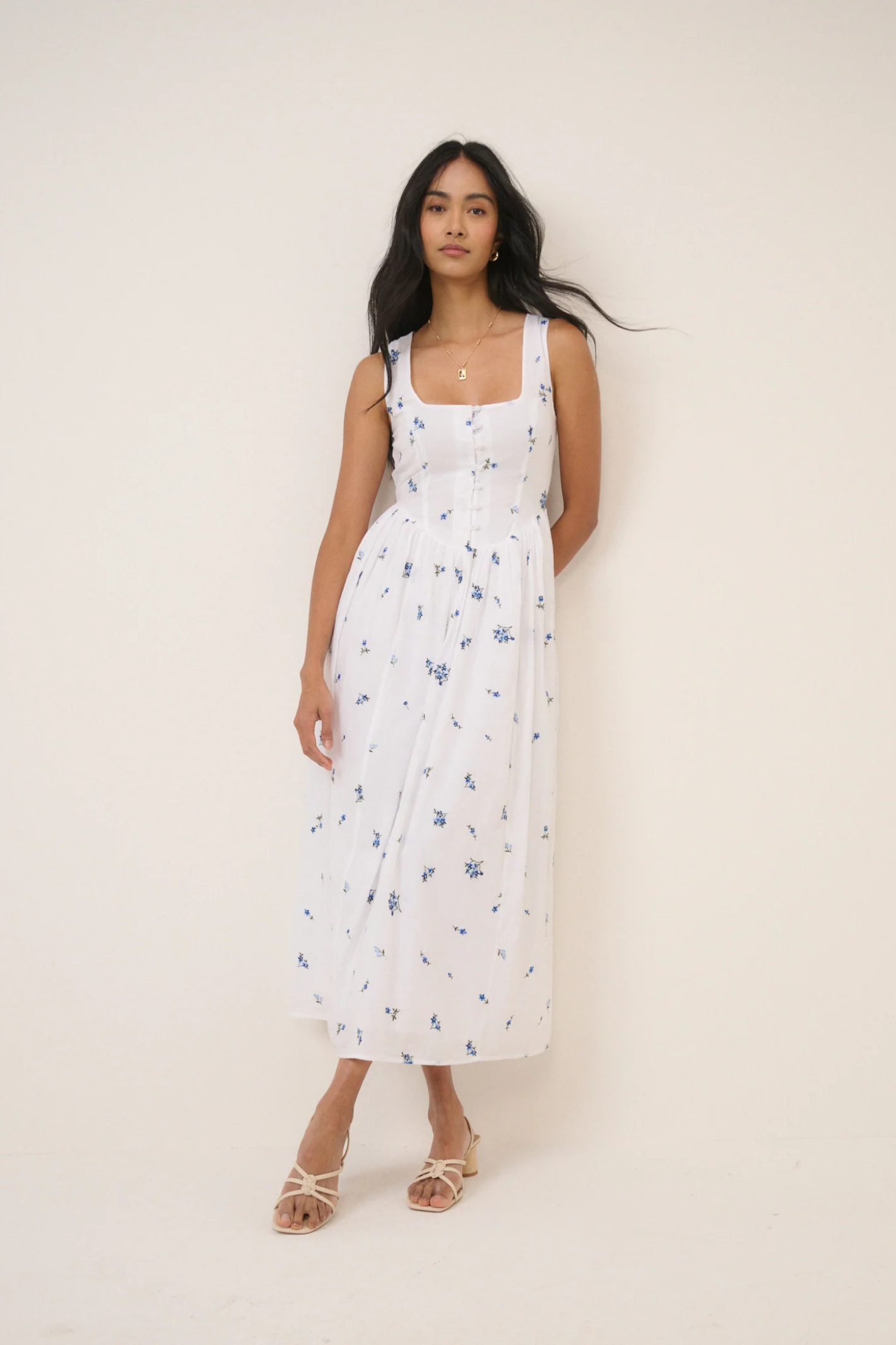 Model wearing Nobody's Child Cora White Midi Dress by Nobody’s Child with blue floral print, shop Nobody’s Child at Dotique.