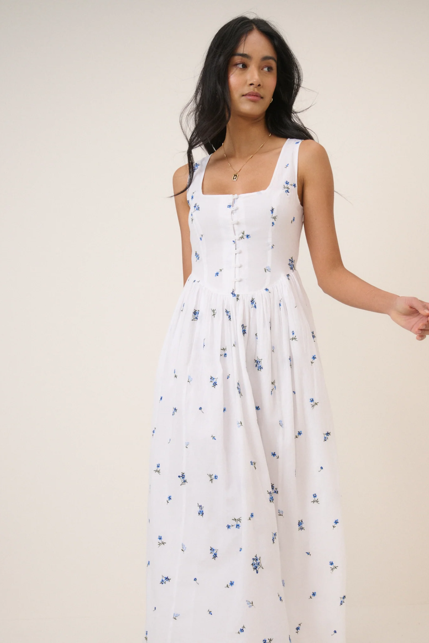 Model wearing Nobody's Child Cora White Midi Dress by Nobody’s Child with blue floral print, shop Nobody’s Child at Dotique.