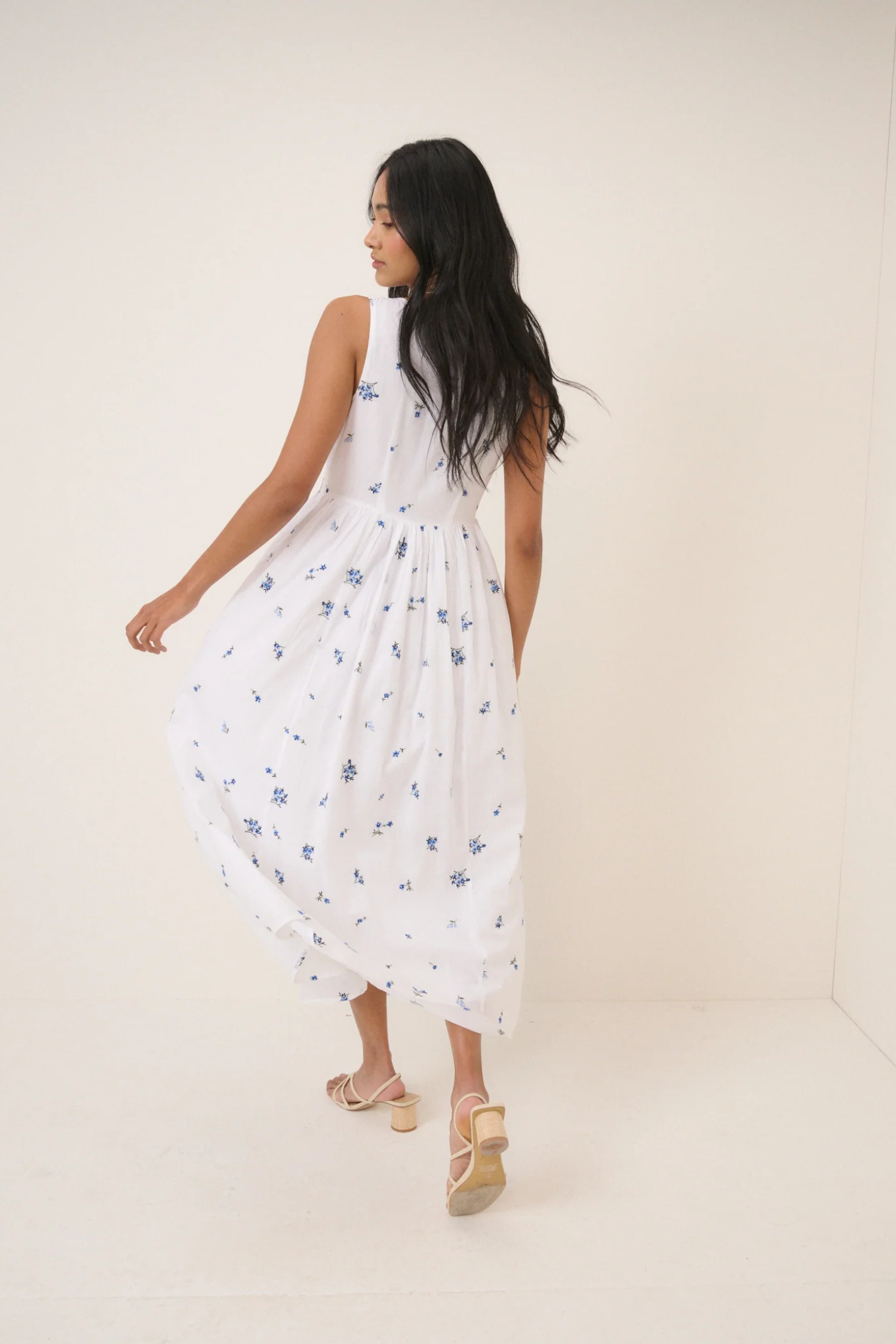 Woman wearing Nobody's Child Cora White Midi Dress with blue floral print by Nobody’s Child, shop Dotique.