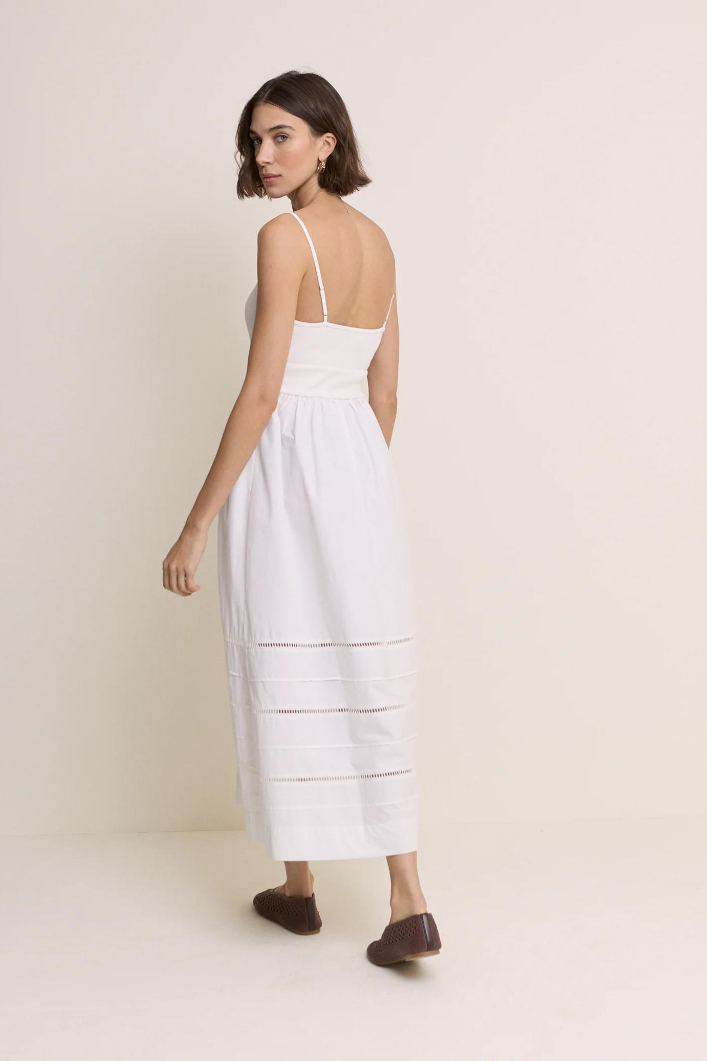 Model wearing Nobody’s Child White Strappy Tiered Goldie Midi Dress with delicate straps and tiered skirt by Nobody’s Child, shop Nobody’s Child at Dotique.