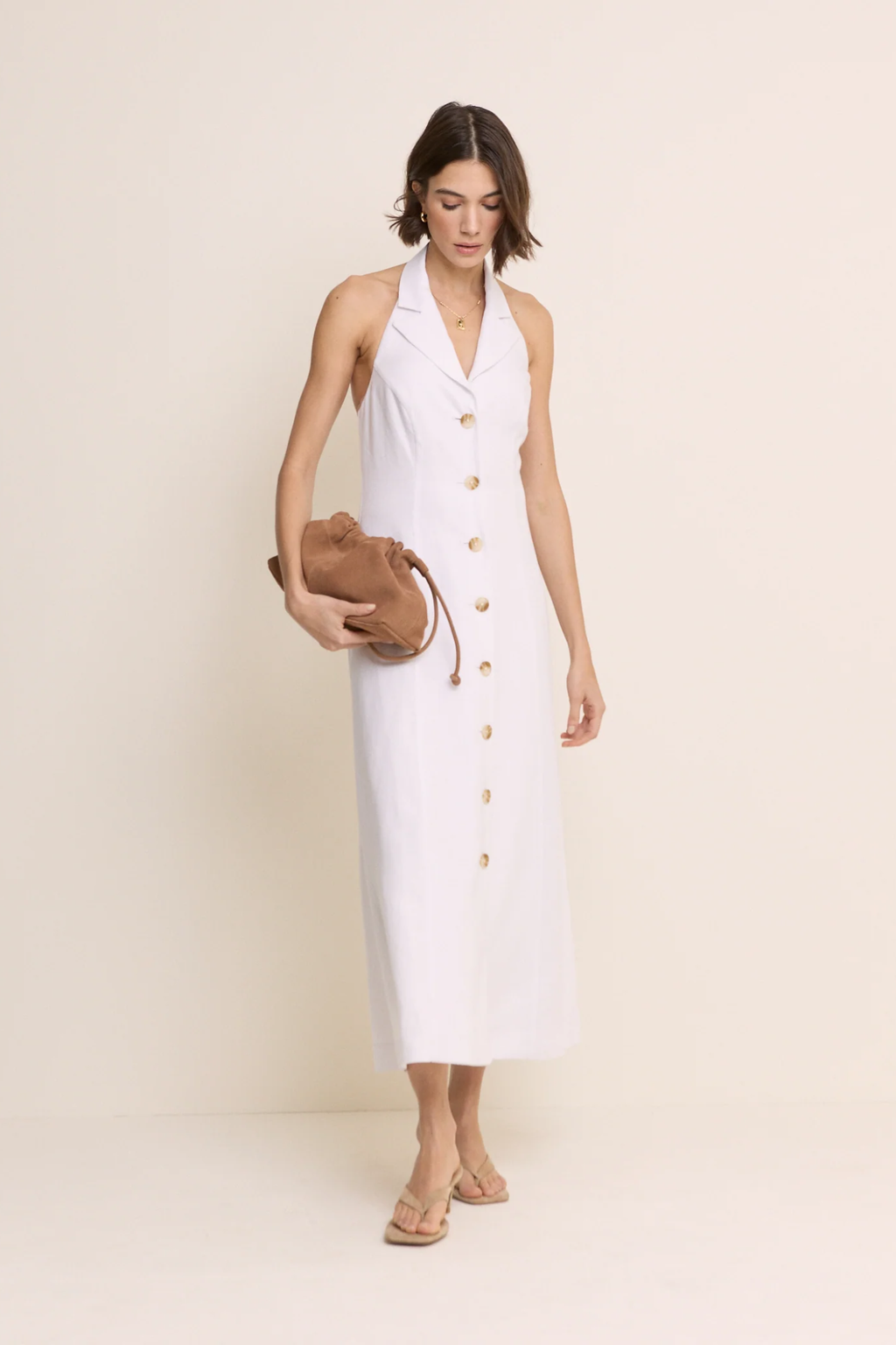 Model wearing Nobody’s Child Halter Tailored Midi Dress in cream with button front detailing by Nobody’s Child, shop Nobody’s Child at Dotique.