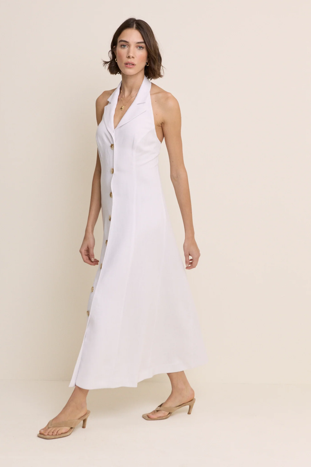 Model wearing Nobody’s Child Halter Tailored Midi Dress in white with button details by Nobody’s Child, shop Nobody’s Child at Dotique