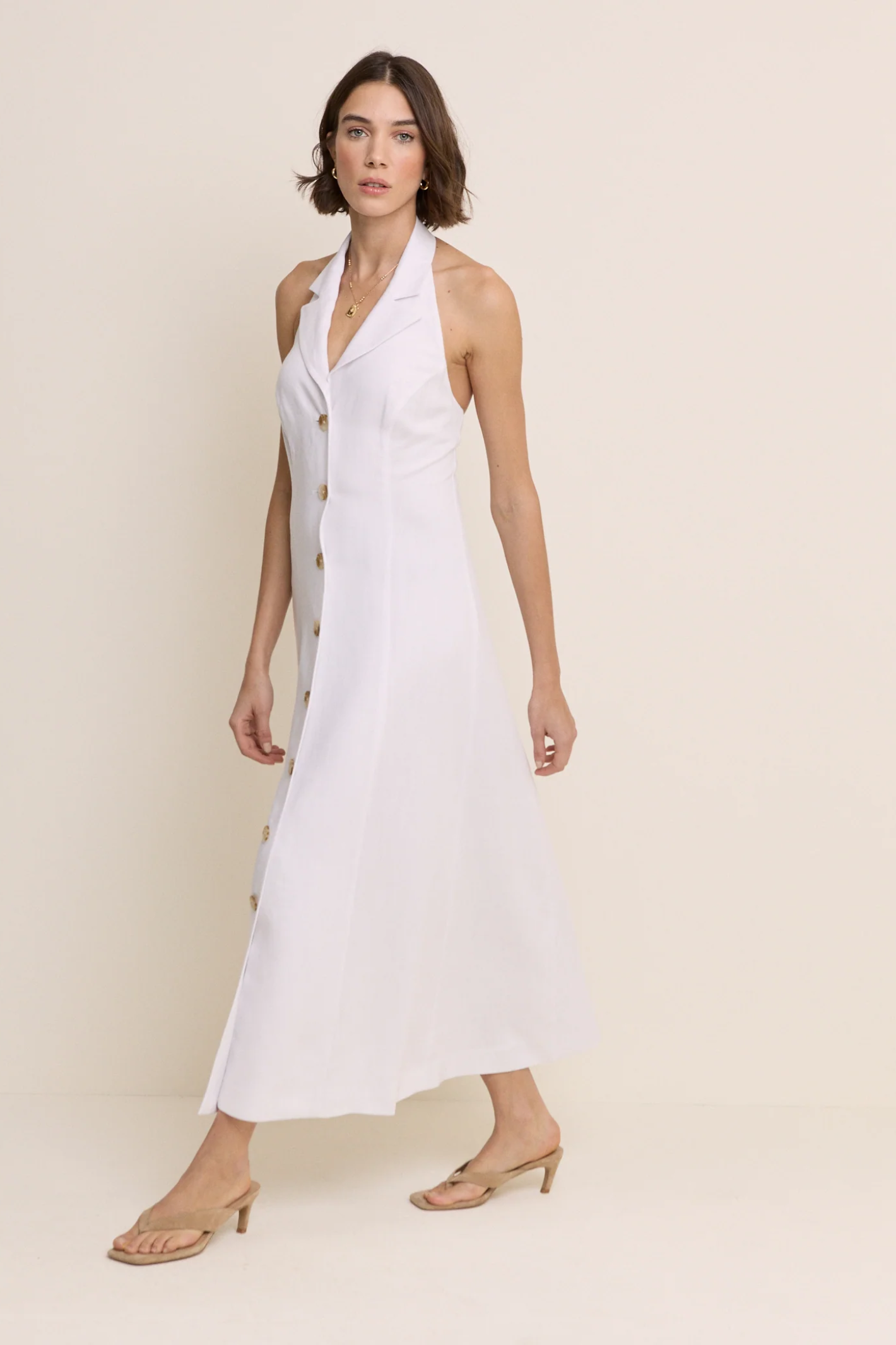 Model wearing Nobody’s Child Halter Tailored Midi Dress in white with button details by Nobody’s Child, shop Nobody’s Child at Dotique