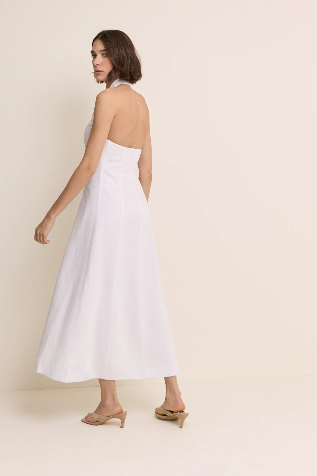 Model wearing Nobody’s Child Halter Tailored Midi Dress in white with an open back by Nobody’s Child, shop Nobody’s Child at Dotique.