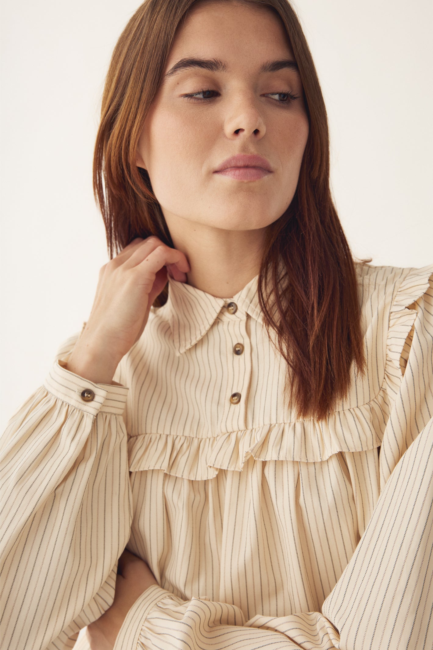 Model showcasing Noella 15360001 N-Mikayla Blouse Donnie Cream Stripe by noella shop noella at Dotique with striped and ruffle detail