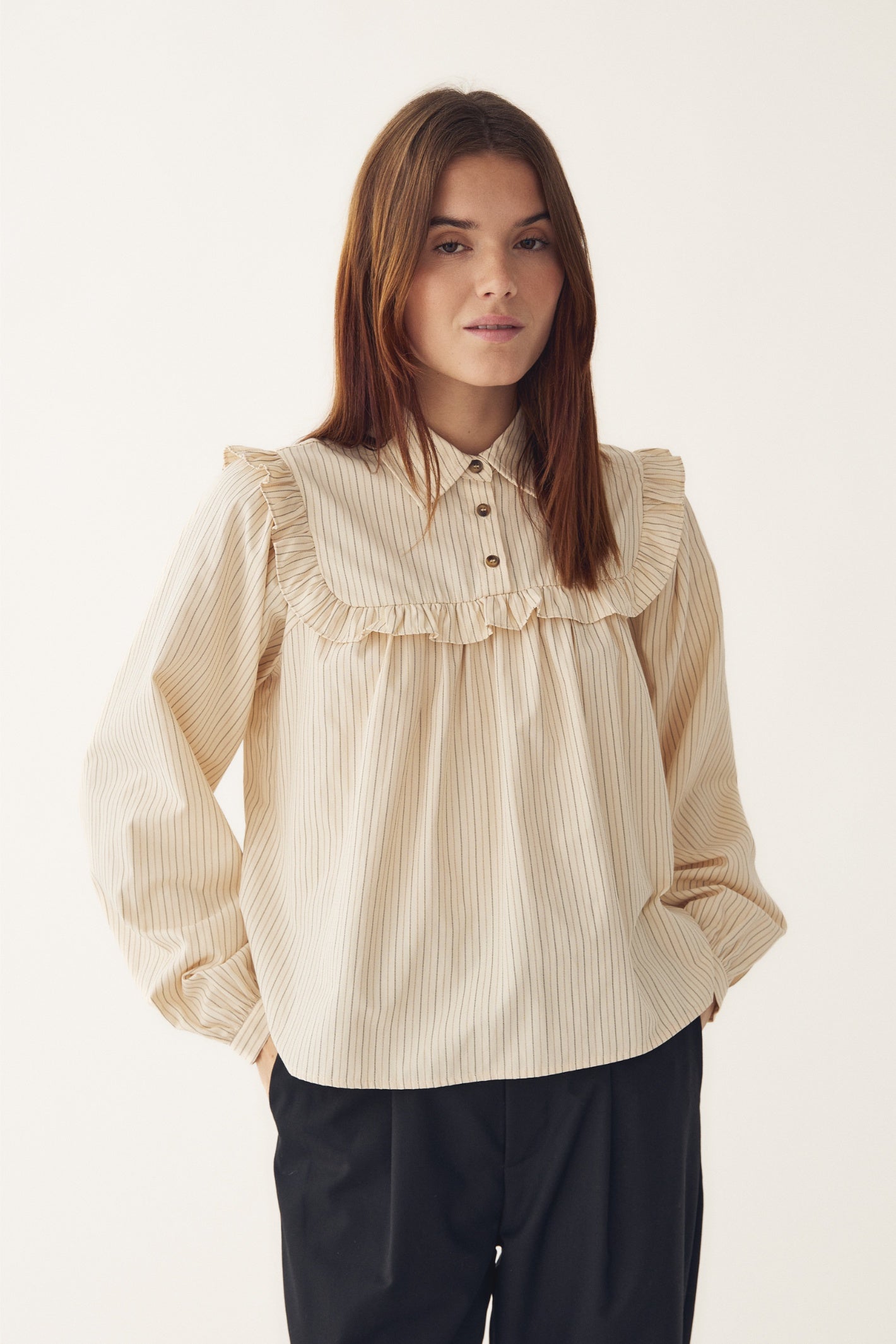 Model wearing Noella 15360001 N-Mikayla Blouse Donnie Cream Stripe by noella with ruffle yoke and button details shop noella at Dotique