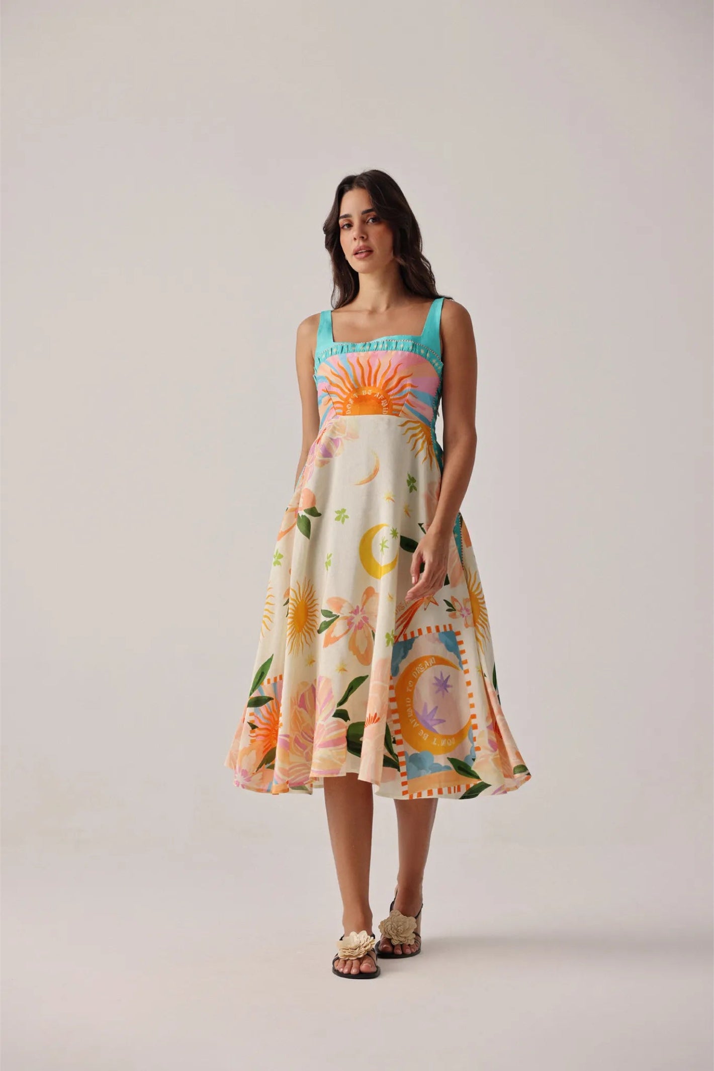 Model wearing NOIB Nora Midi Azure Print Viscose Linen Dress by Noib with vibrant sun and floral motifs, shop Noib at Dotique