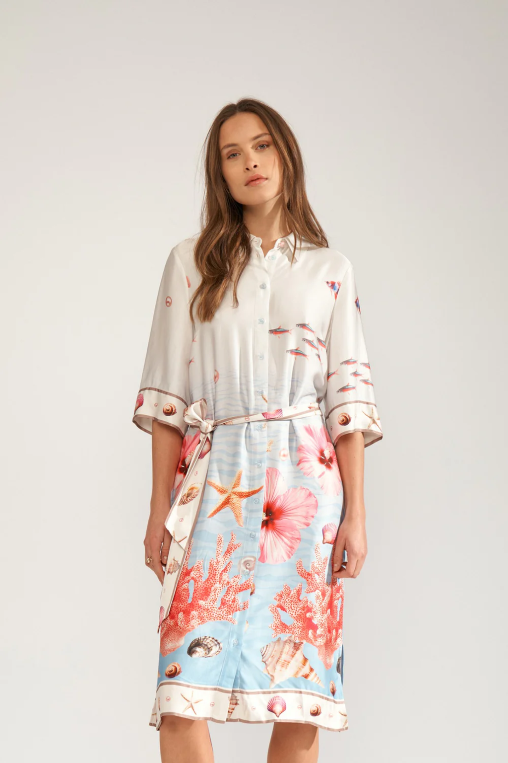 Model wearing Numph 706753 Nuoceana Shirt Dress Skyway by Numph featuring a sea-inspired print with coral and shells, shop Numph at Dotique.