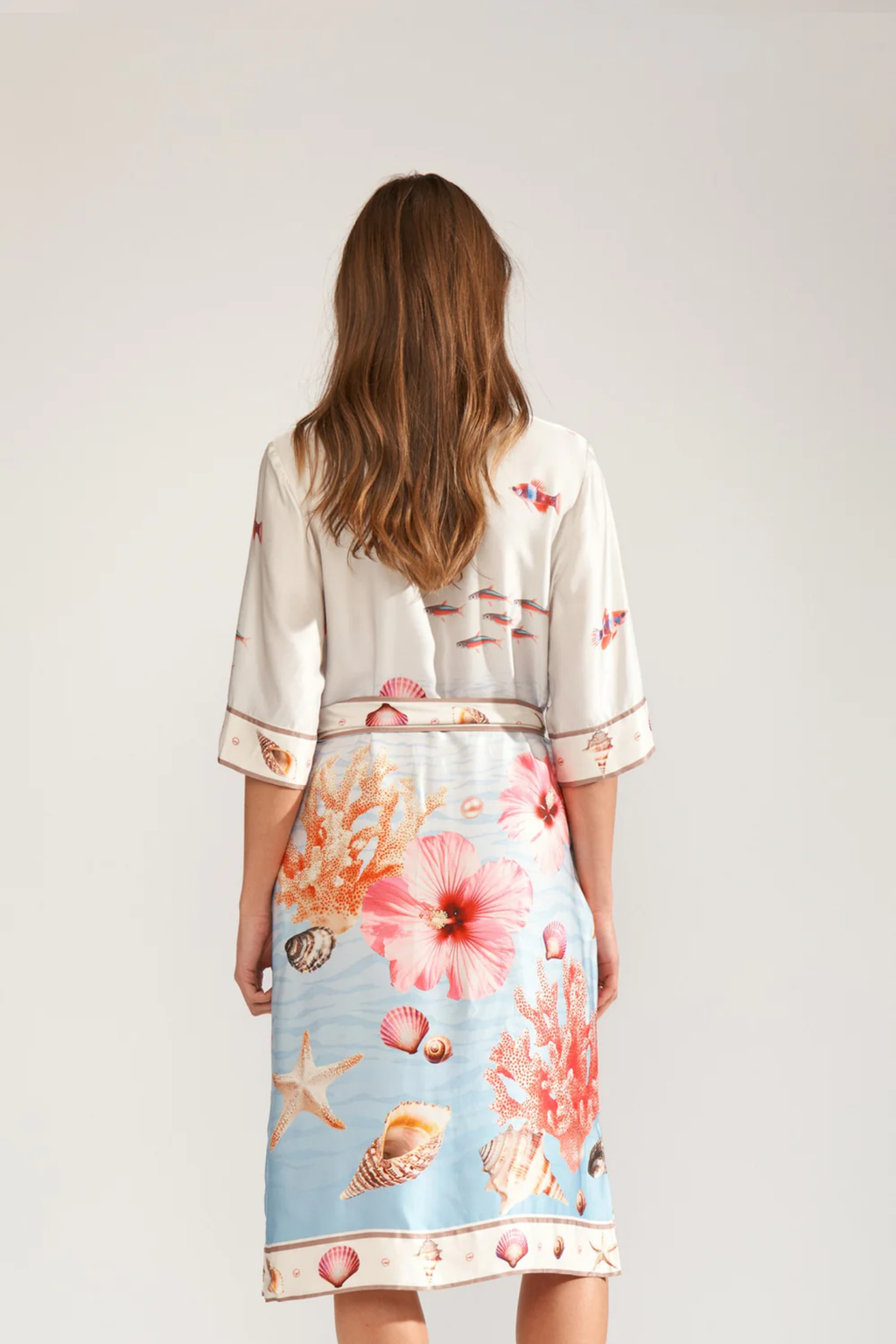 Back view of a model wearing Numph 706753 Nuoceana Shirt Dress Skyway by Numph, featuring sea-inspired coral and shell prints, shop Numph at Dotique.