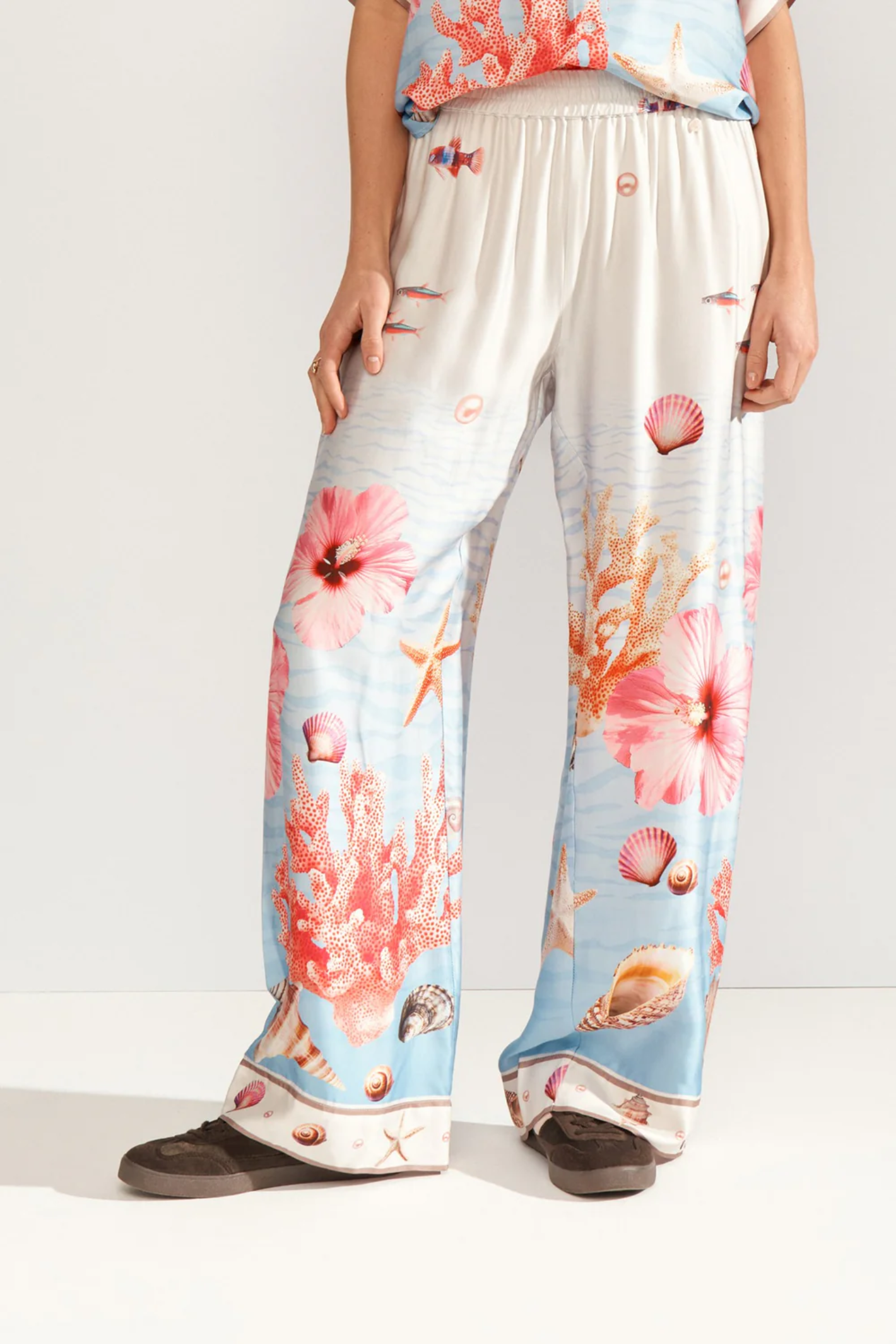 Model wearing Numph 707149 Nuoceana Wide Leg Trousers – Skyway with coral and seashell print by Numph, shop Numph at Dotique.