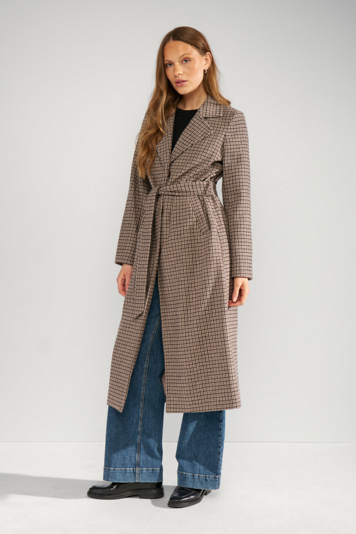 Shop the Nümph NUELANA Coat in Black Coffee at Dotique. A long checked wool-blend coat with a tie waist, perfect for autumn and winter layering.