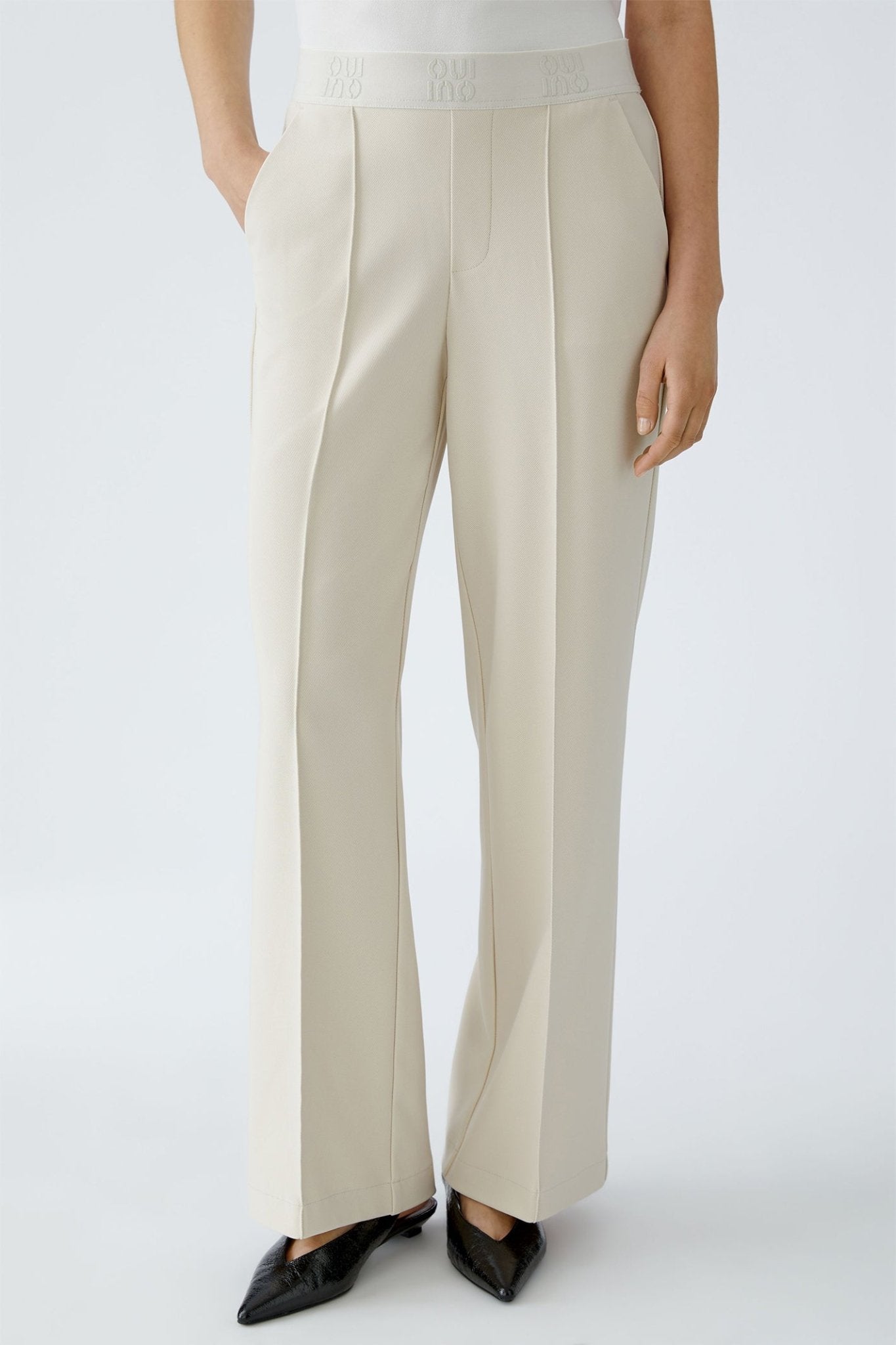 Beige pants worn by a person on a white background