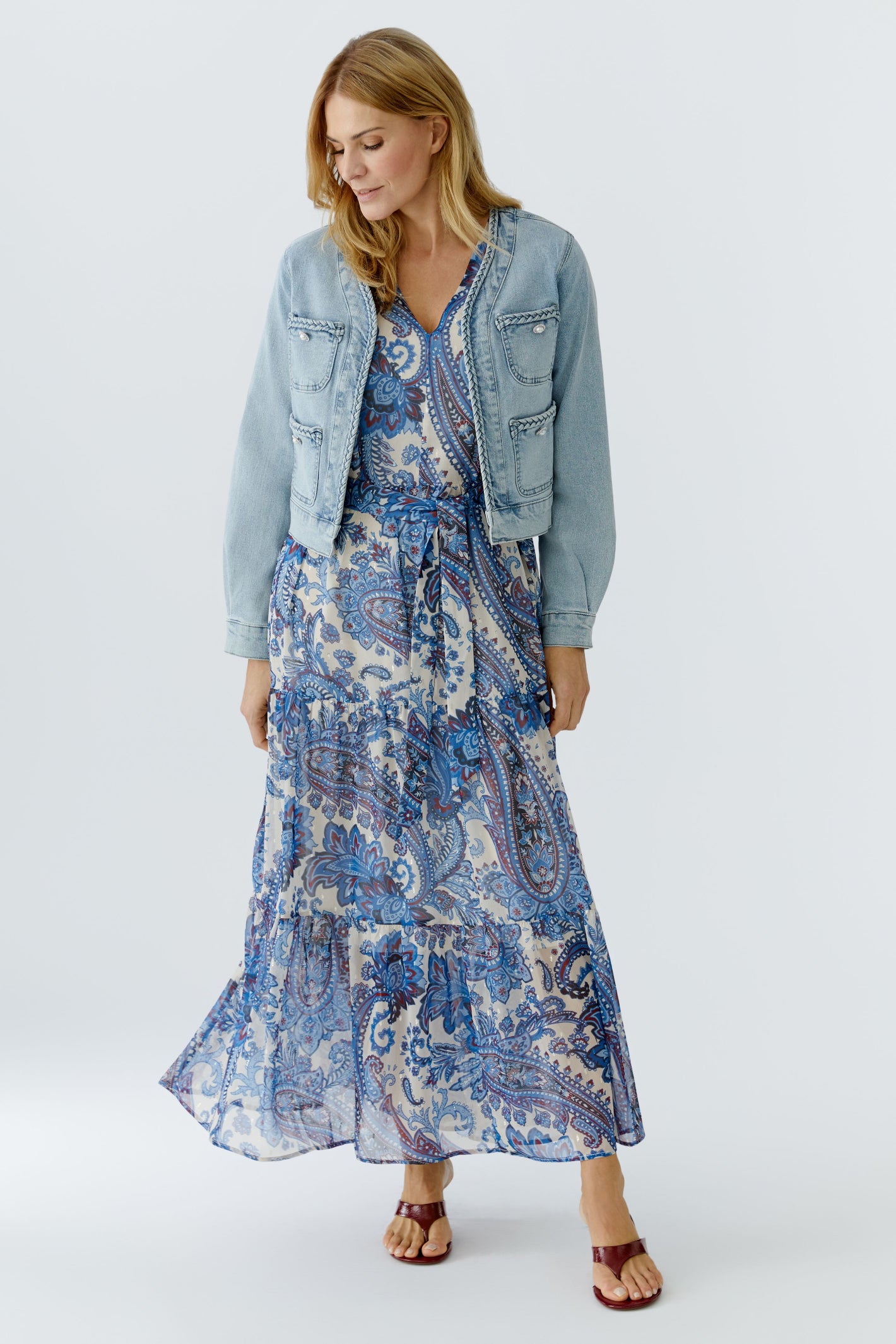 Model wearing Oui 96342 Light Denim Jacket by Oui styled with patterned maxi dress Shop Oui at Dotique for modern layered looks