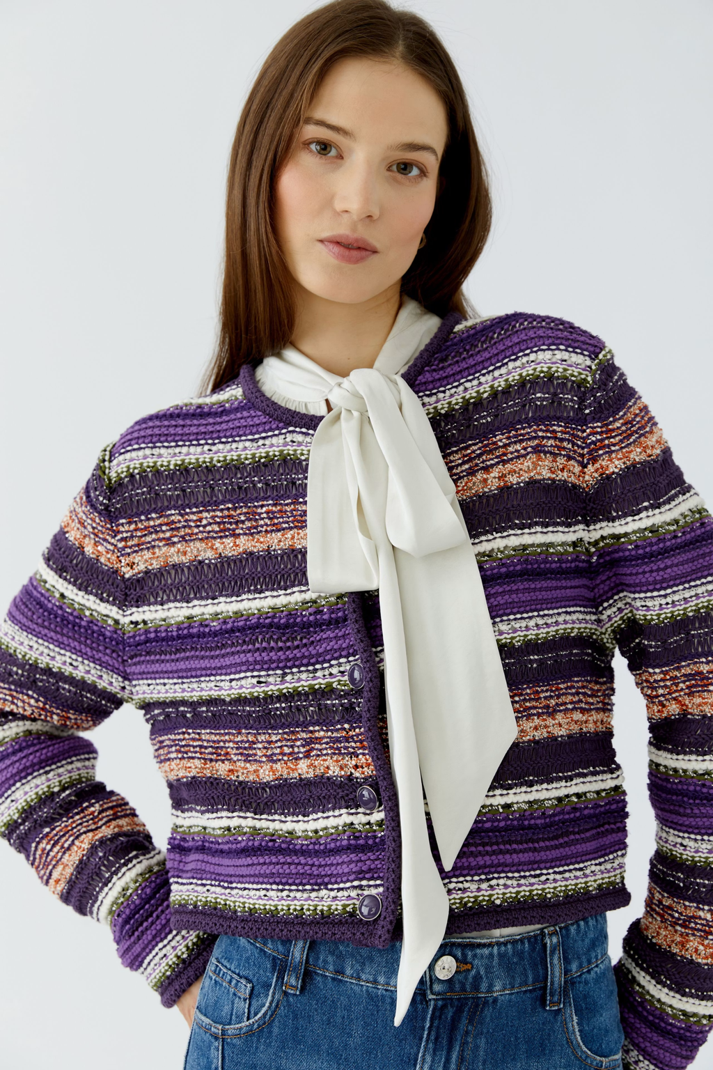 Make a colourful statement with this striking Oui knit cardigan, woven in a special yarn mix that combines rich purple, orange and green stripes with a subtle shimmer of micropaillettes. Cut in a narrow, shortened silhouette, it has a round neckline finished with a neat trim and slim, fitted sleeves for a flattering, considered shape. Valuable metal buttons run down the front for a refined finishing touch.