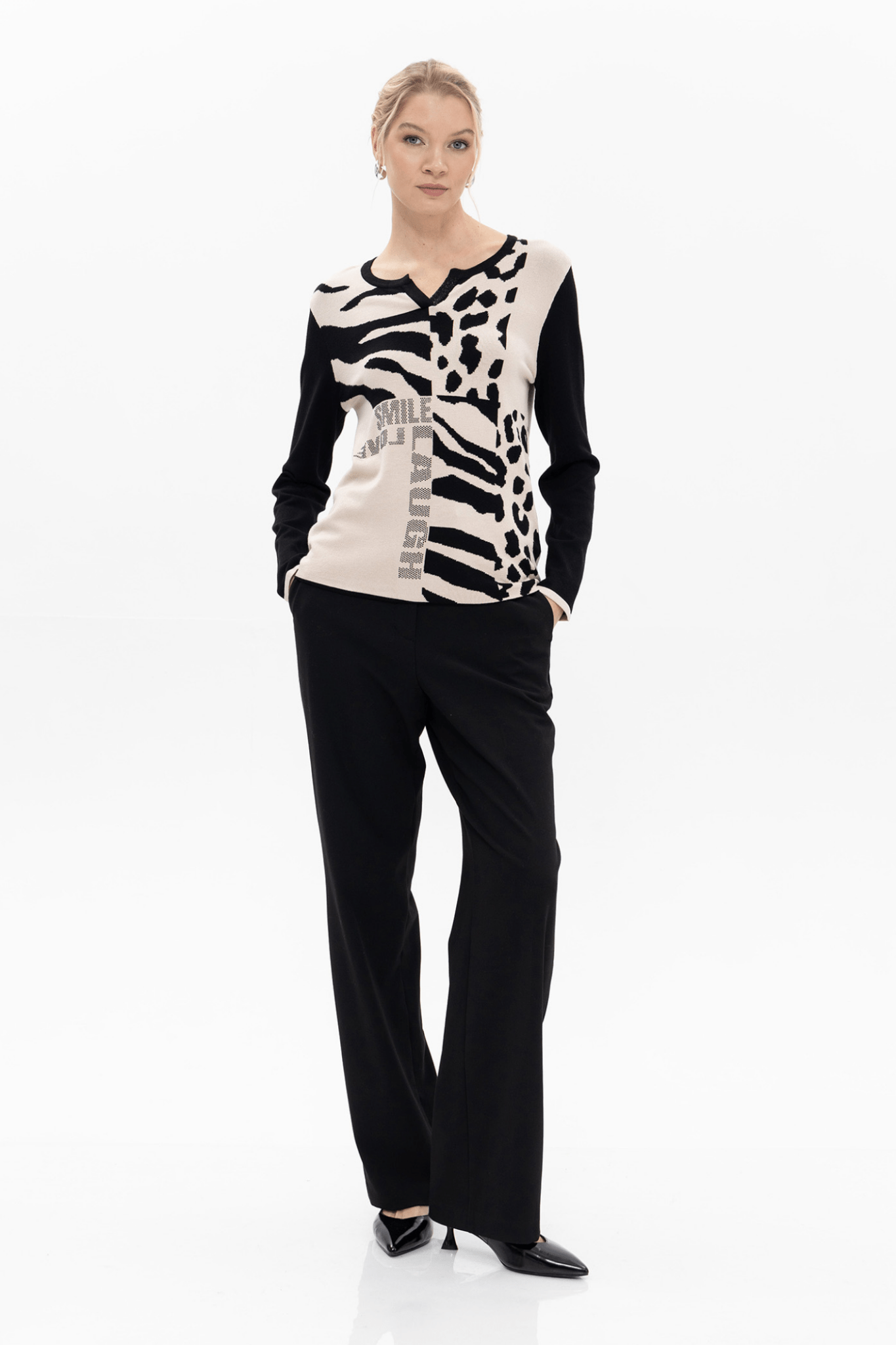 Woman wearing a black and white patterned top with black pants on a white background.Passioni 18158 Leopard Mix Print Jumper