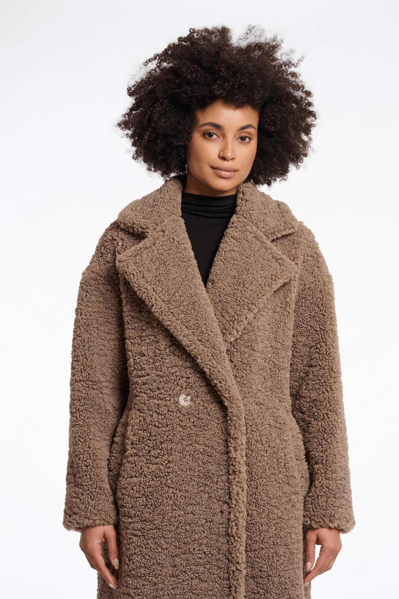 Woman wearing a brown teddy coat on a white background