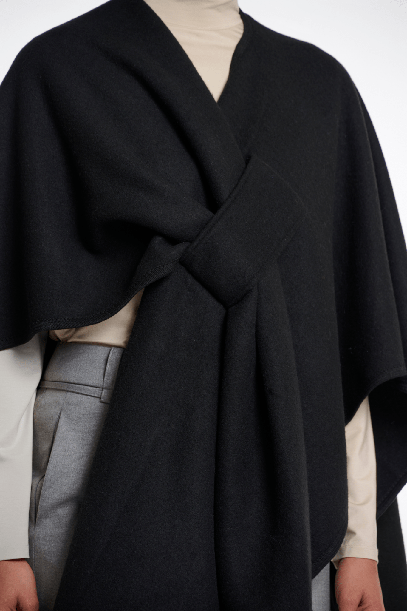 Black wrap over a neutral outfit on a white background