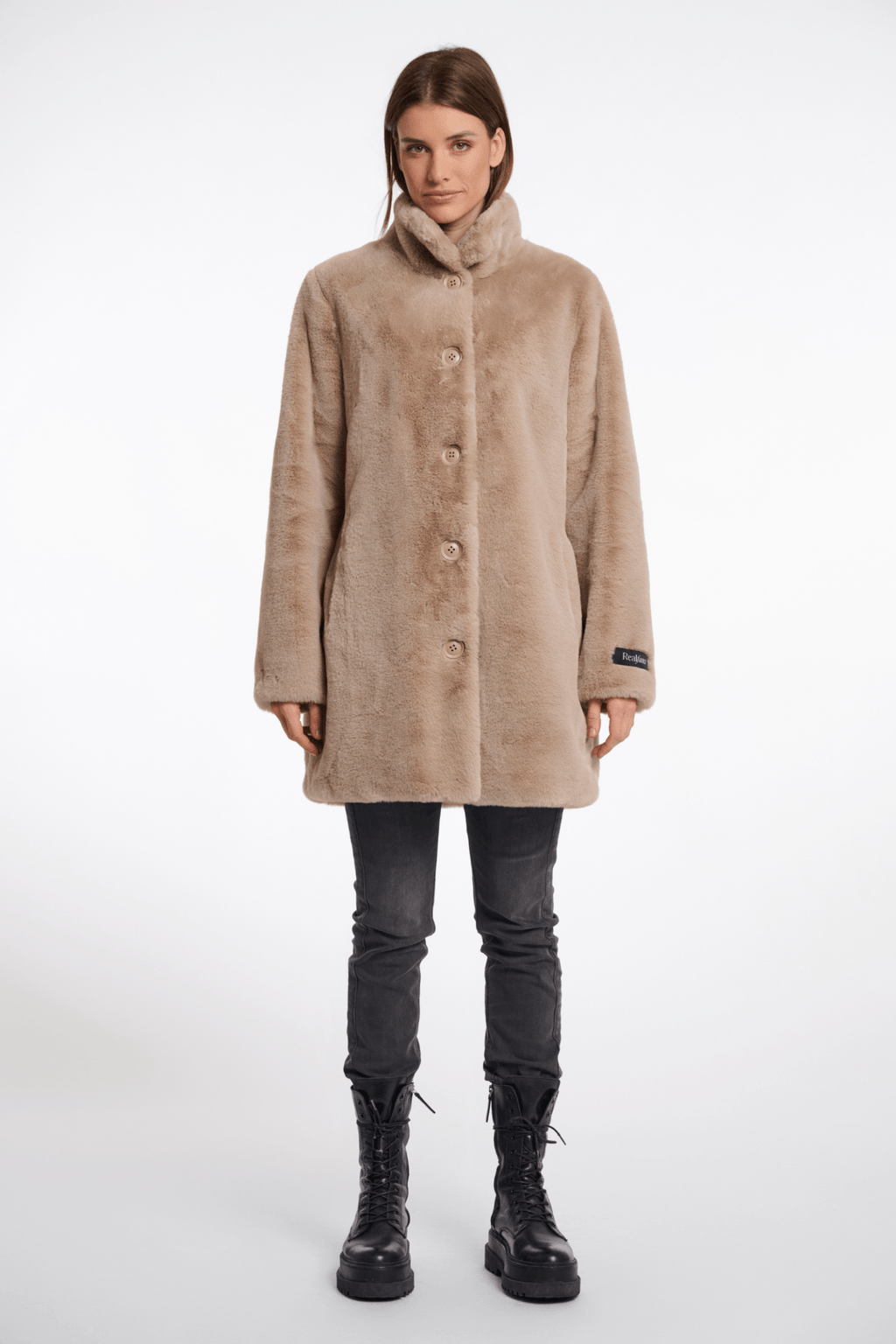 Woman wearing a beige coat on a white background