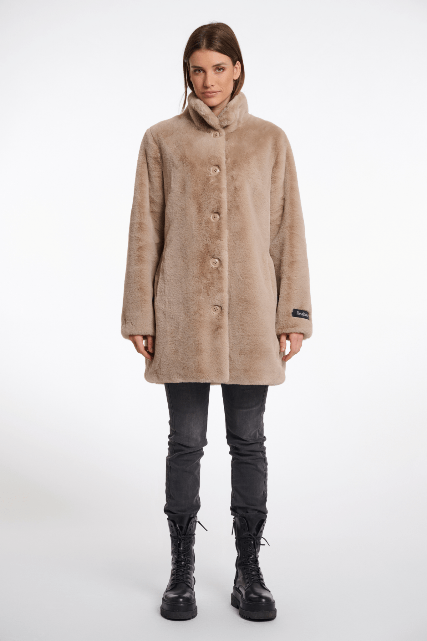 Woman wearing a beige coat on a white background