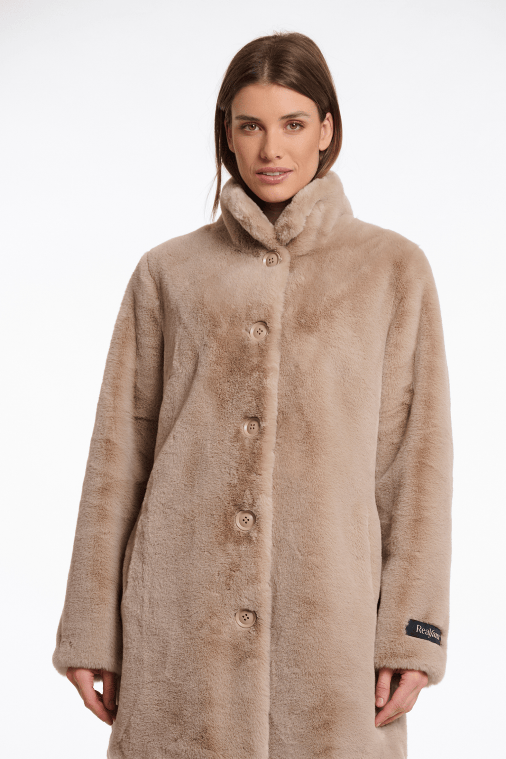 Woman wearing a beige coat with a fur-lined hood on a white background