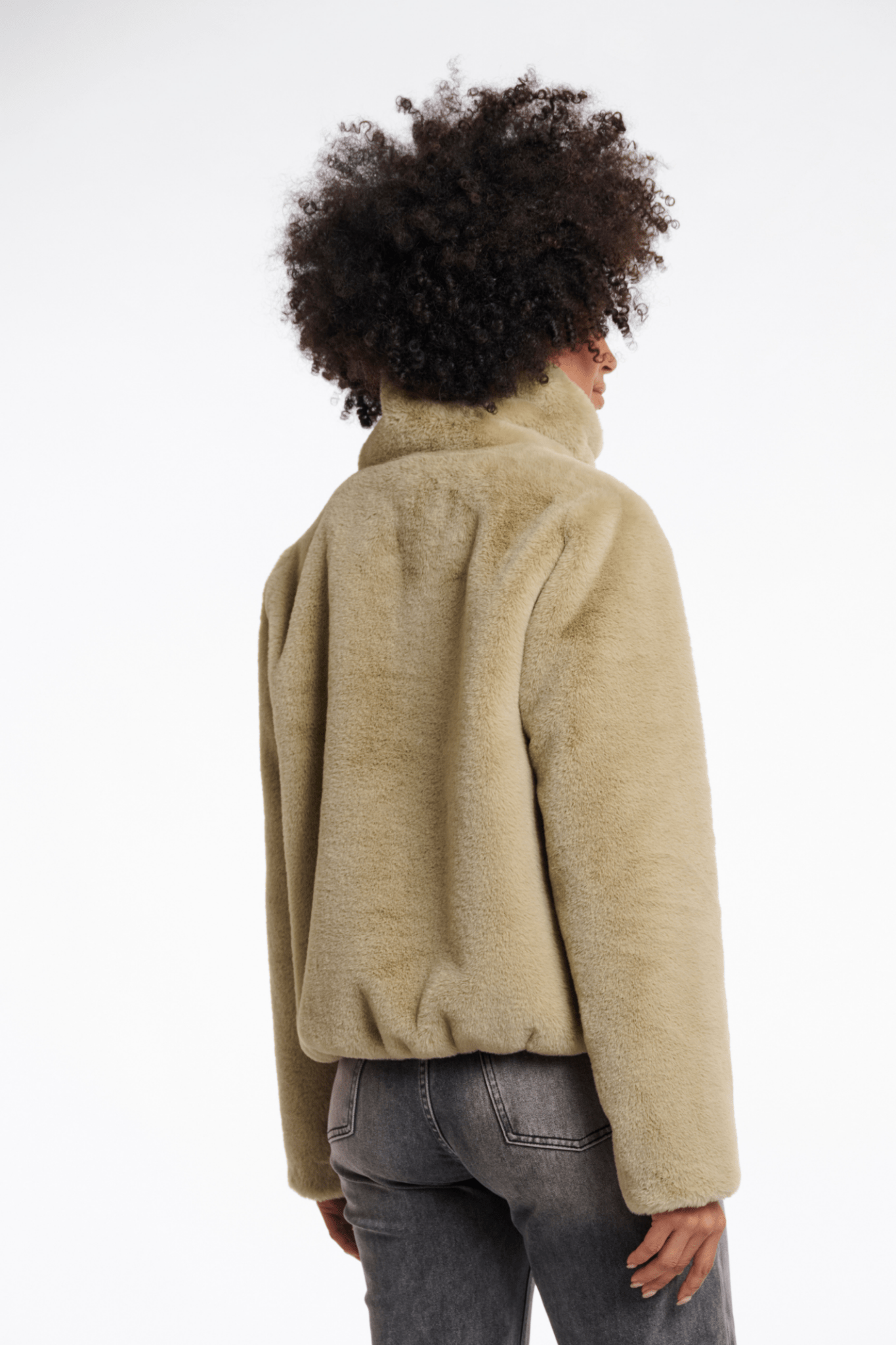 Person wearing a beige fleece jacket on a white background