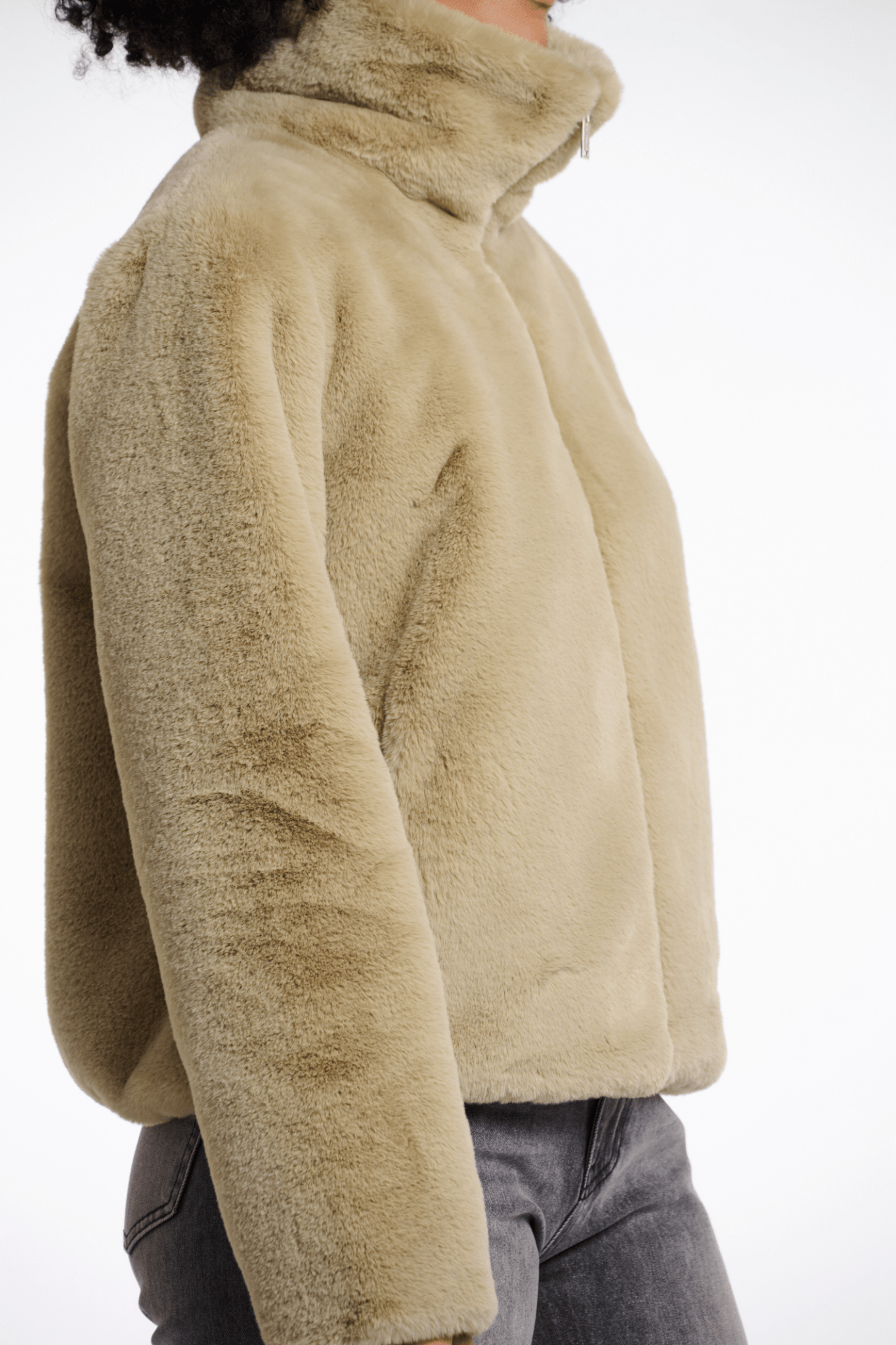 Beige fleece jacket worn by a person on a white background
