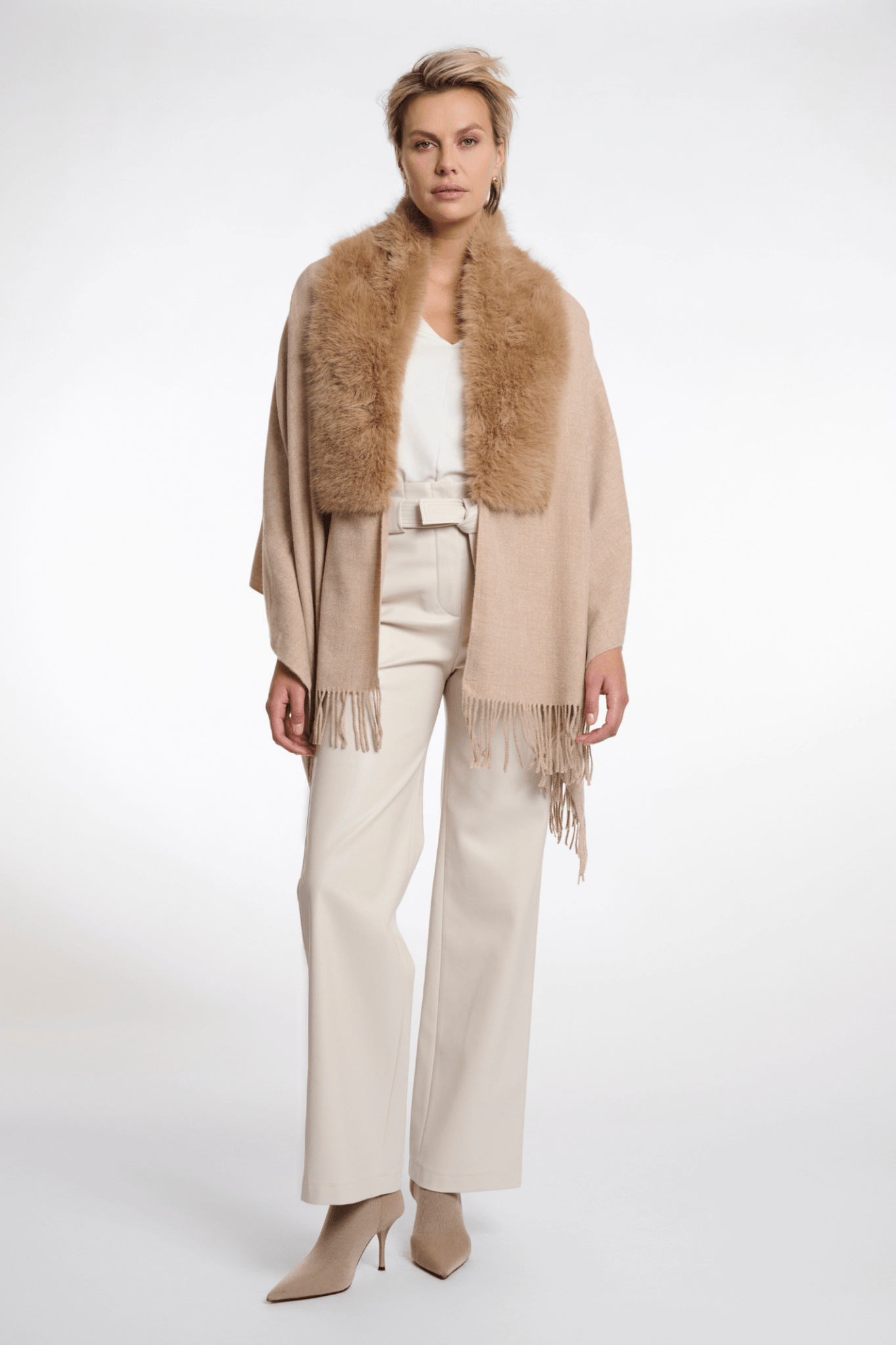 Woman wearing a beige scarf with fur trim on a white background