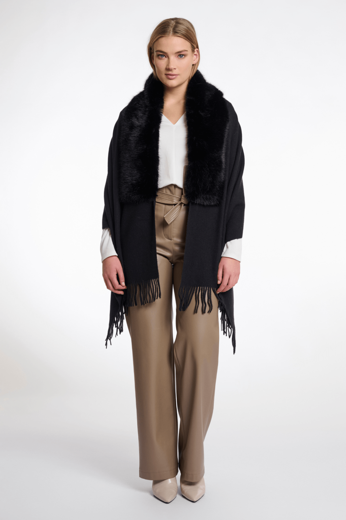 Woman wearing a black fringed scarf with a white background