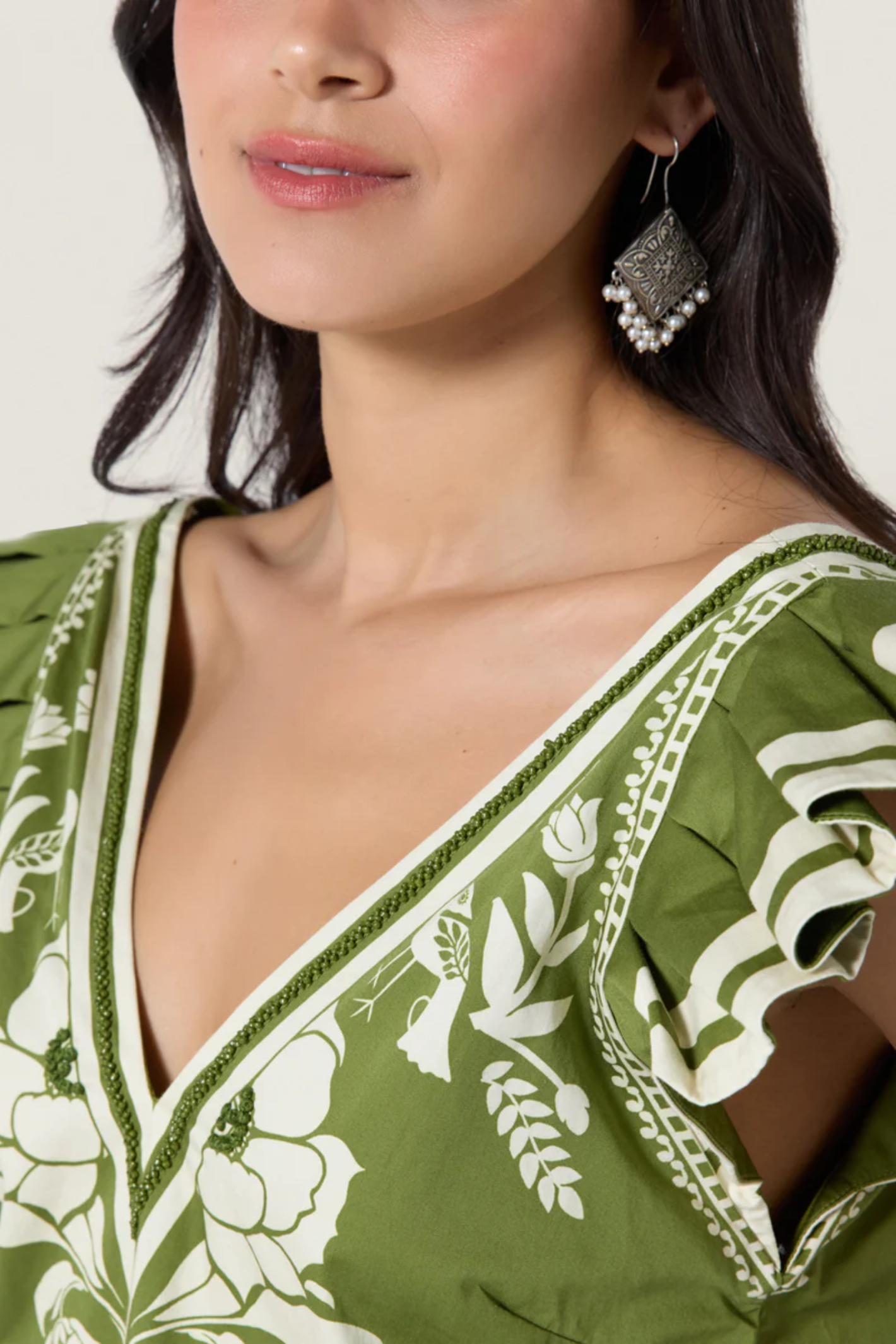 Close-up of a woman wearing Scarlett Poppies Vittore Top Calla Green/Papyrus from Scarlett Poppies, shop Scarlett Poppies at Dotique