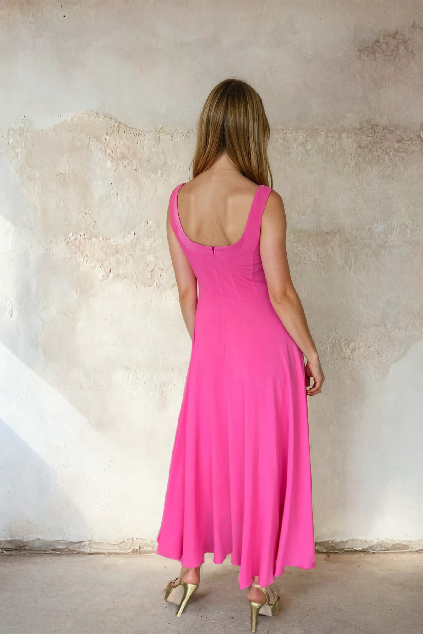 Back view of a woman wearing Sirens Sleeveless Pink Bella Dress with a flowing silhouette and square neckline by Sirens. Shop Sirens at Dotique.