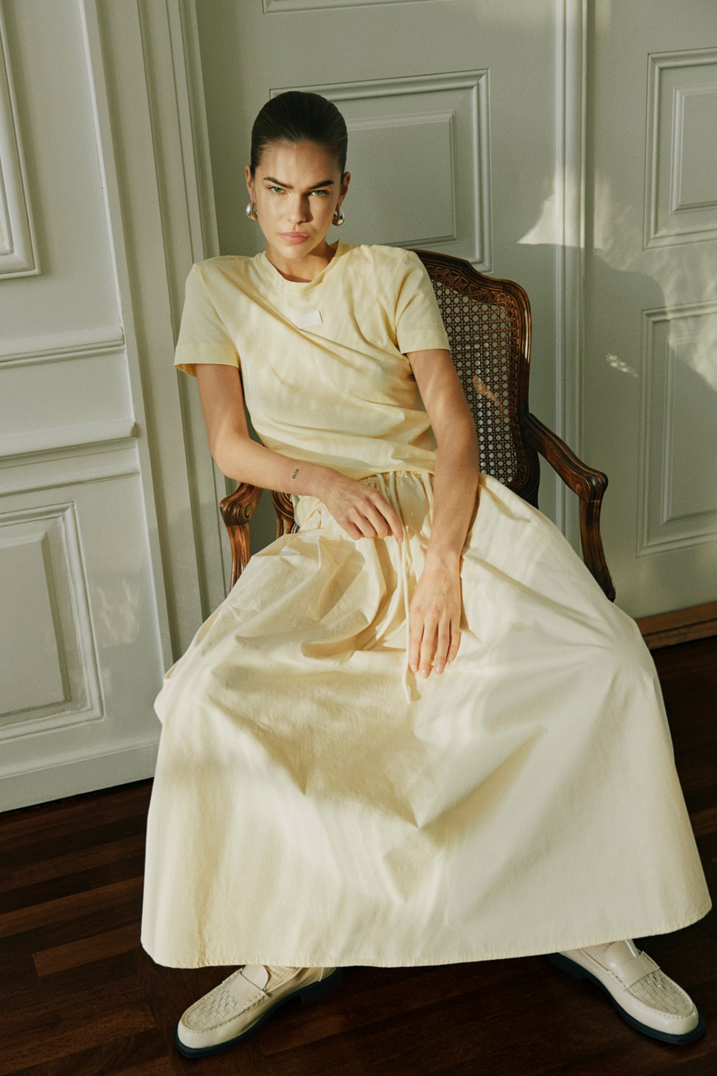 Model seated wearing Sofie Schnoor S261311 Mikkasw Boat-Neck Blouse – Light Yellow, shop Sofie Schnoor at Dotique gallery 1