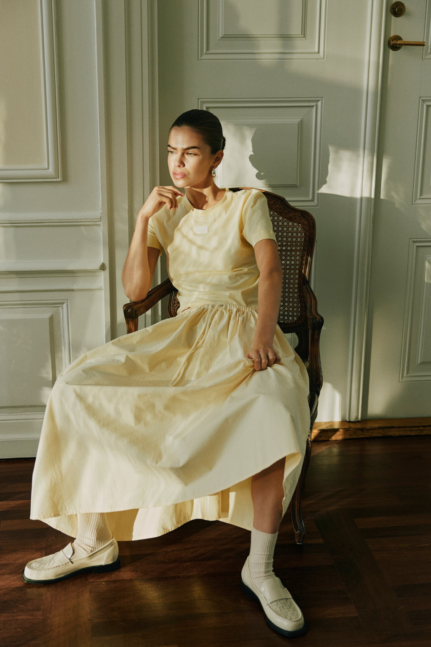 Model seated wearing Sofie Schnoor S261312 Juneausw Midi Skirt – Light Yellow, shop Sofie Schnoor at Dotique gallery 1
