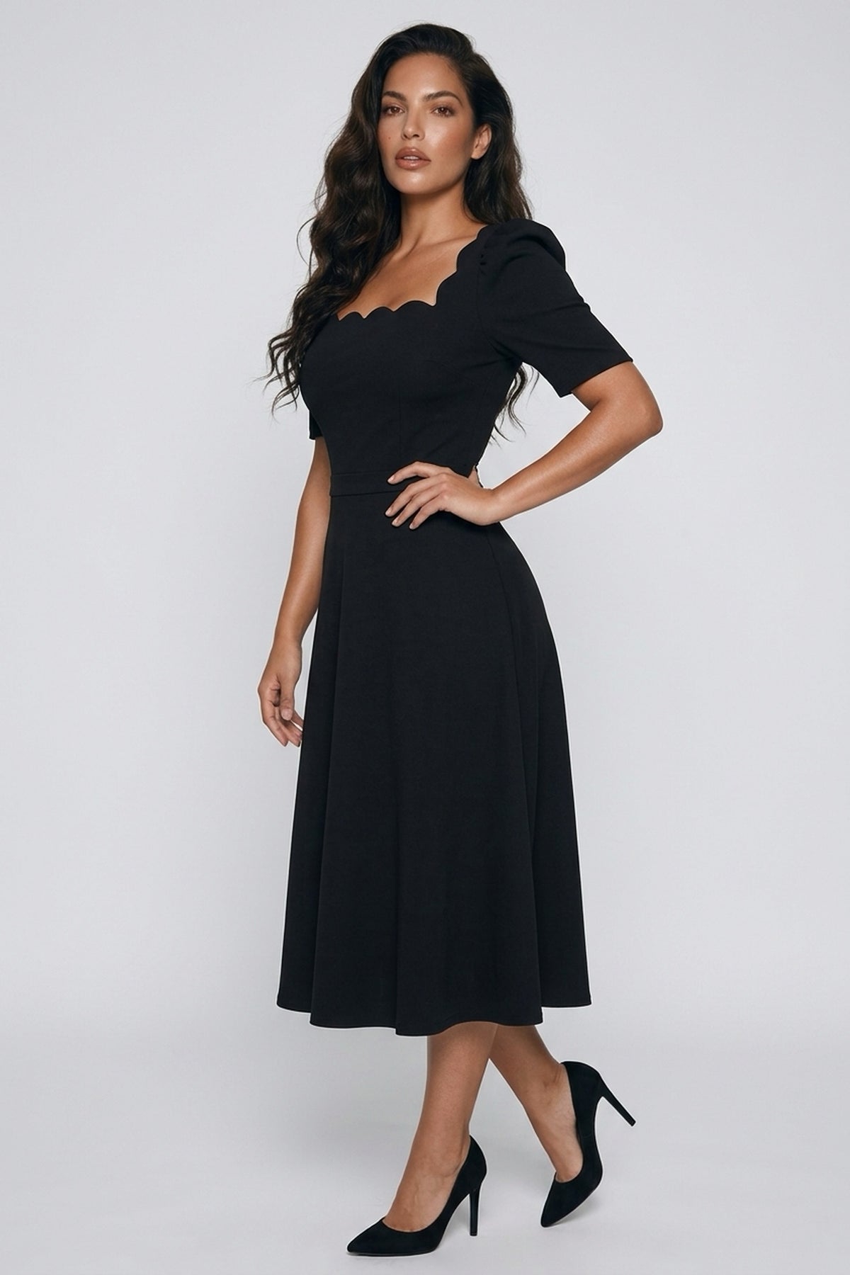 Angled front view of a model wearing The 8th Sign Livia scallop midi dress in black