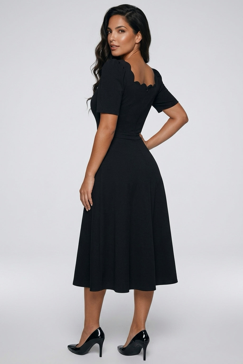 Angled back view of a model wearing The 8th Sign Livia scallop midi dress in black