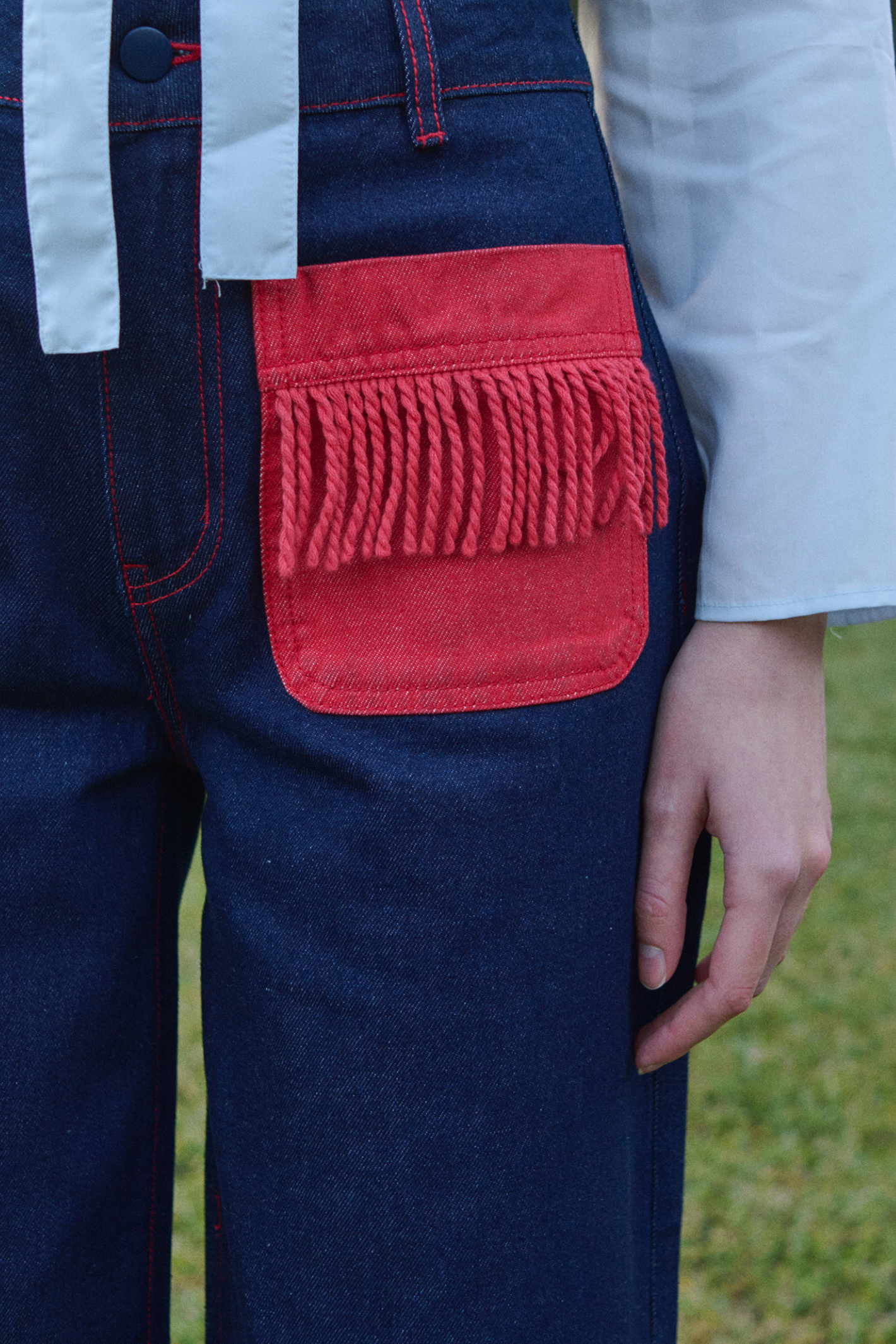 Shop The Tiny Big Sister wide-leg denim trousers in indigo with contrast red fringed pockets. 100% Cotton statement denim at Dotique.